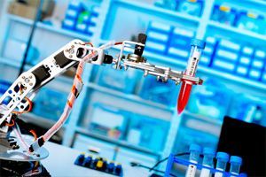 Un braccio robotico tiene una provetta in un laboratorio.