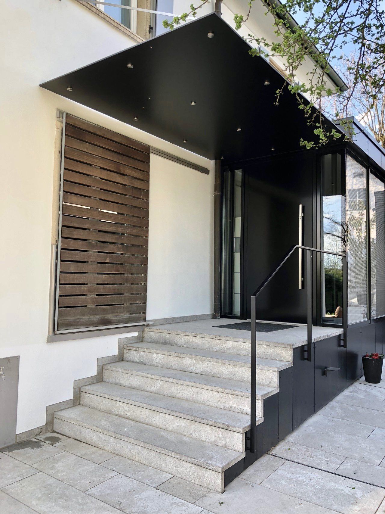 Ein weißes Gebäude mit Treppen, die zur Eingangstür führen