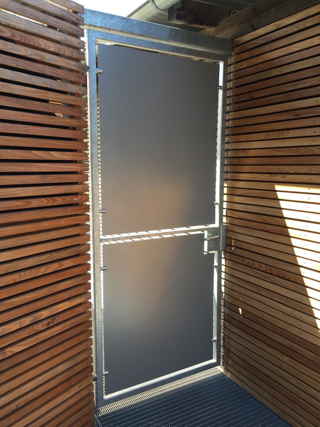 Eine Tür mit einem Holzzaun dahinter