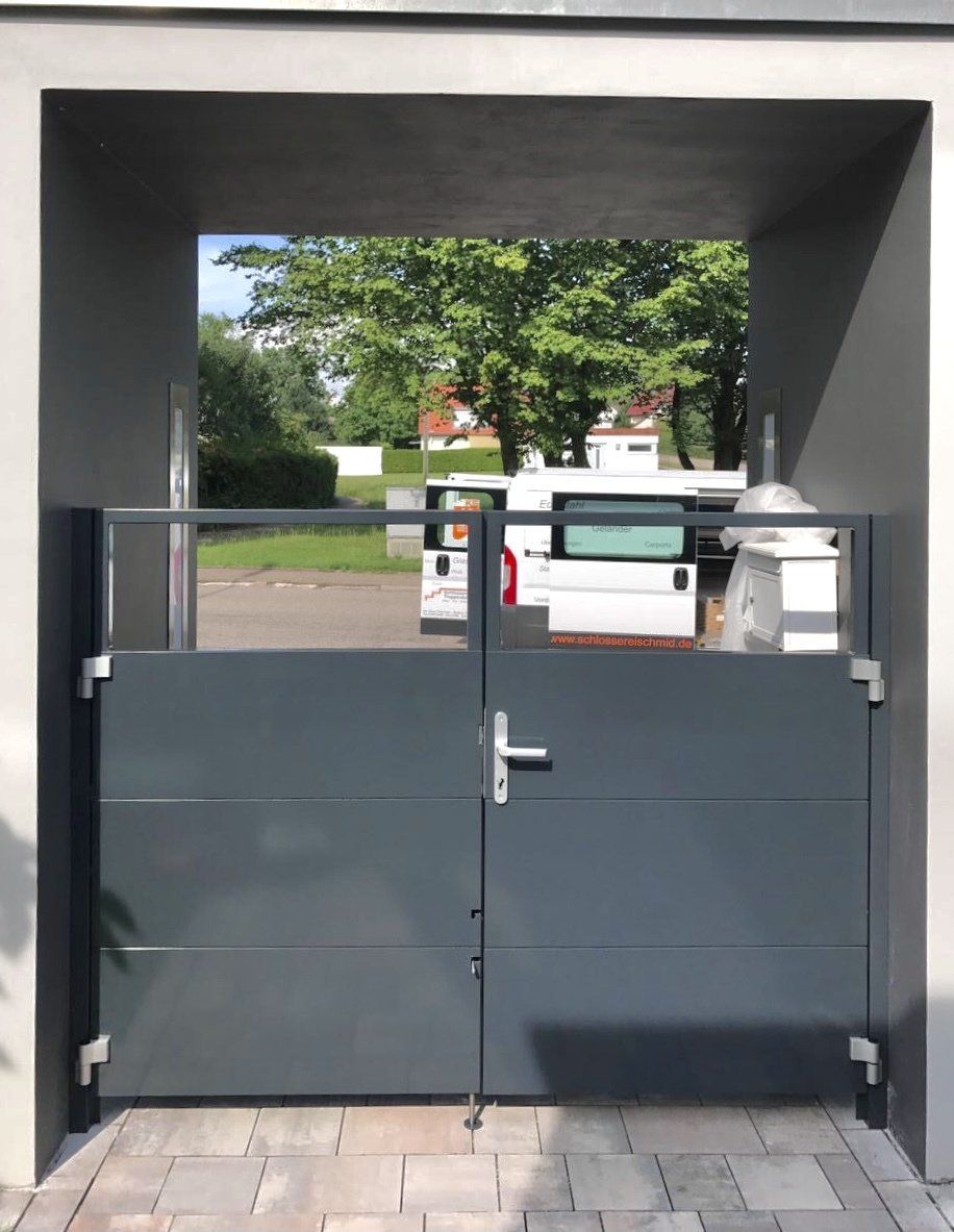 Ein weißer Lieferwagen steht hinter einem schwarzen Tor