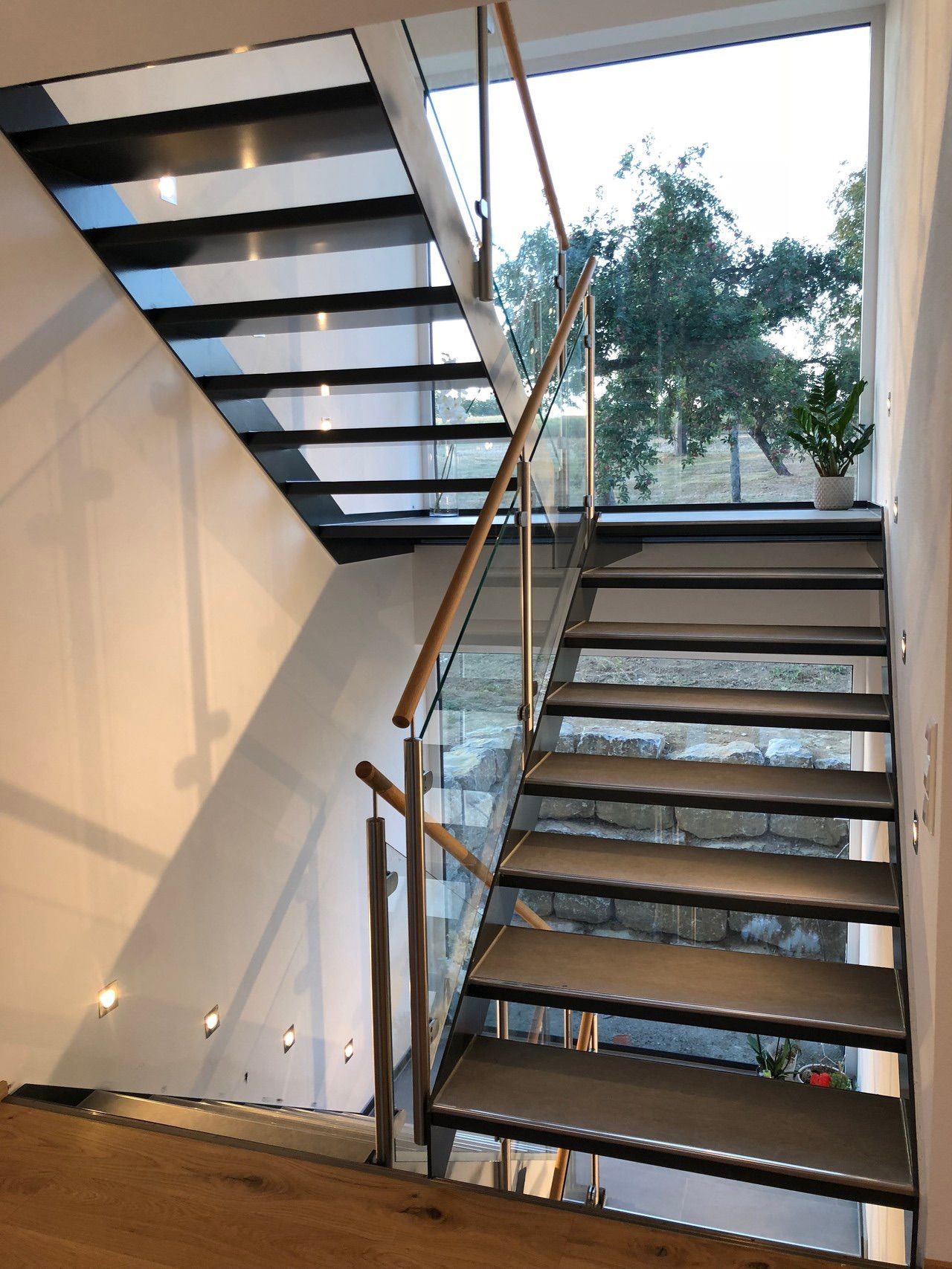 Eine Treppe mit Glasgeländer und Fenster