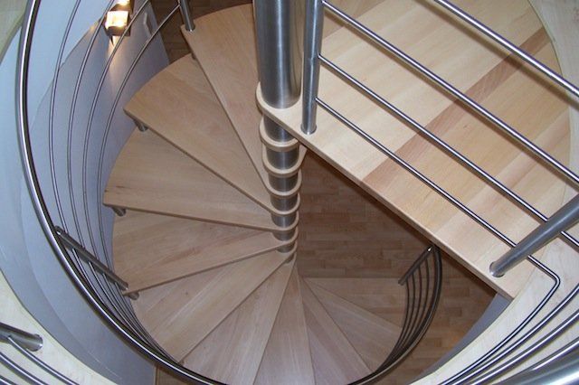 Eine Wendeltreppe mit Holzstufen und einem Metallgeländer