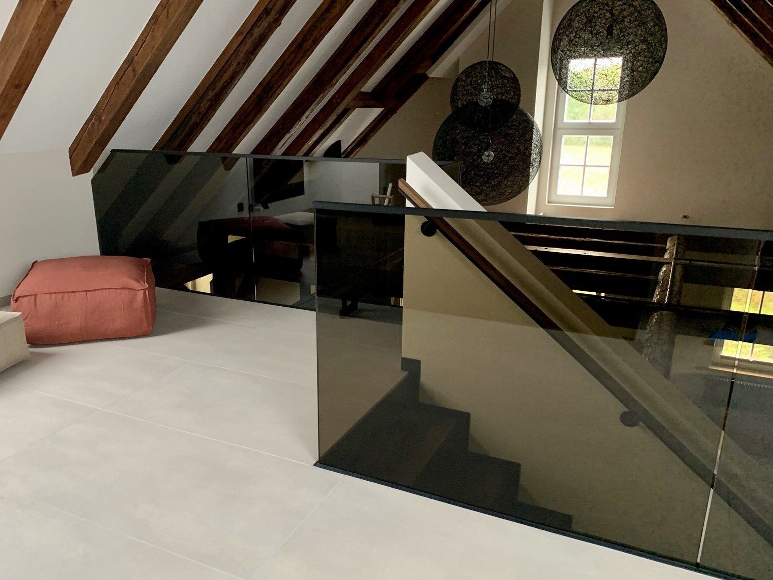 Eine Treppe in einem Dachgeschoss mit einem Glasgeländer