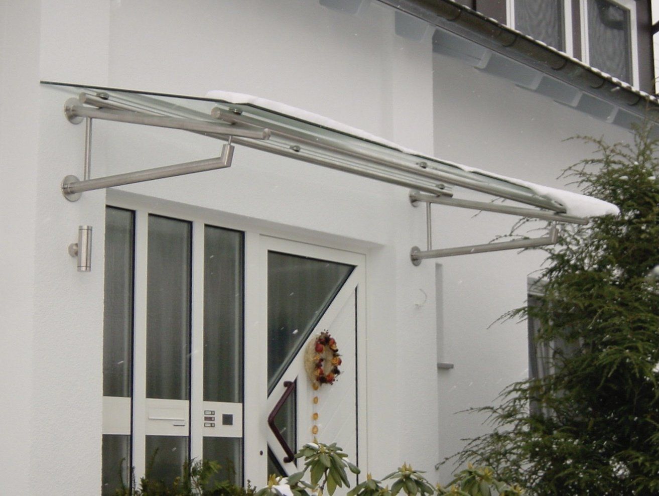 Ein weißes Haus mit einem Vordach über der Tür