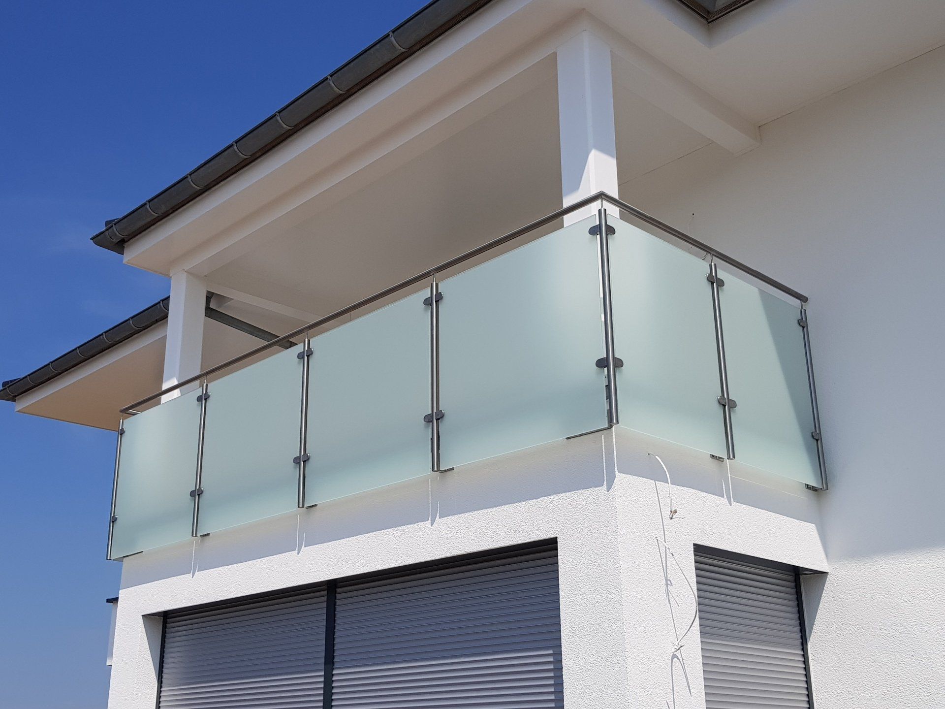 Ein Balkon mit Edelstahlgeländer und Milchglas