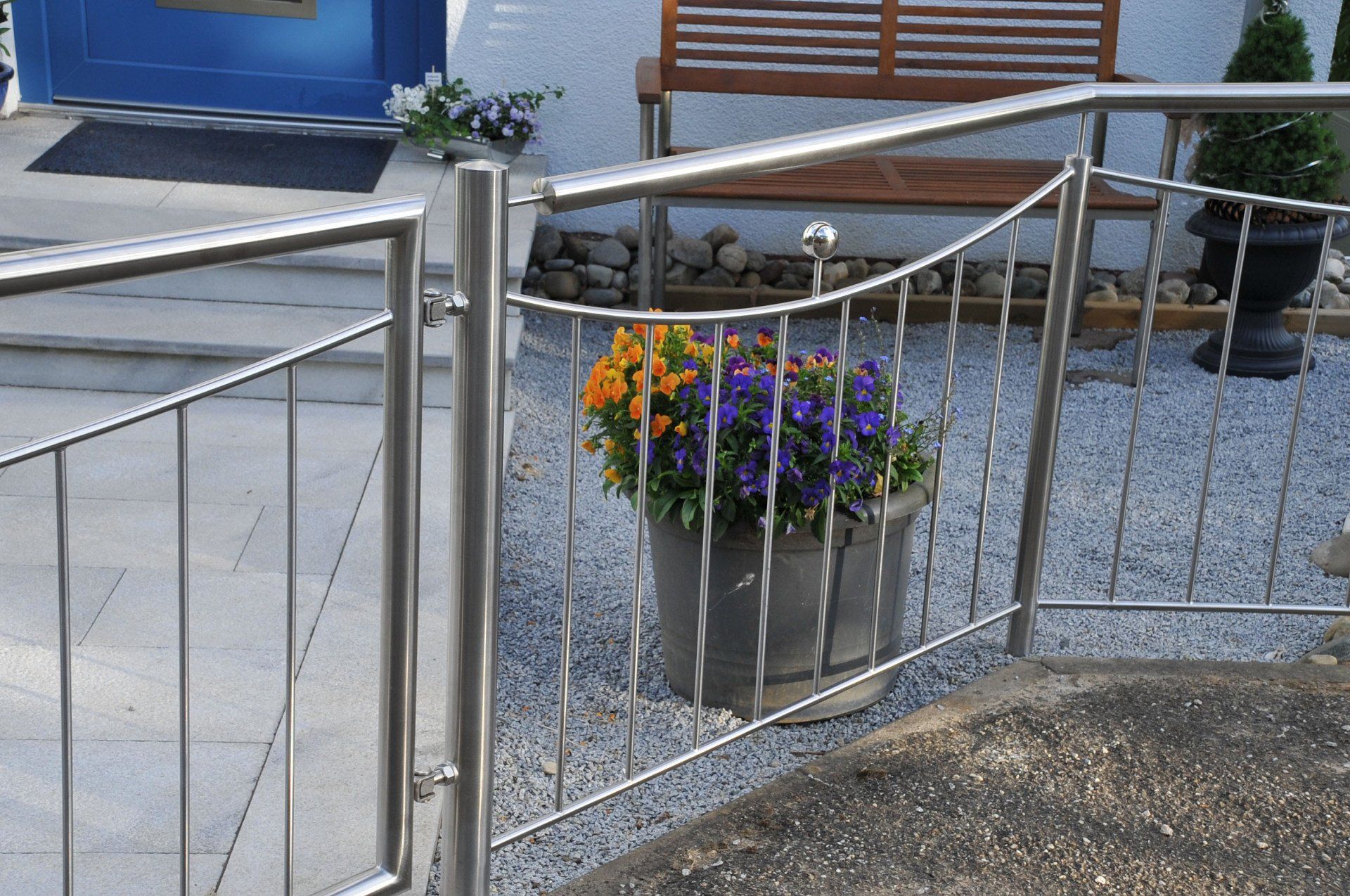 Ein Edelstahlzaun mit einem Blumentopf dahinter