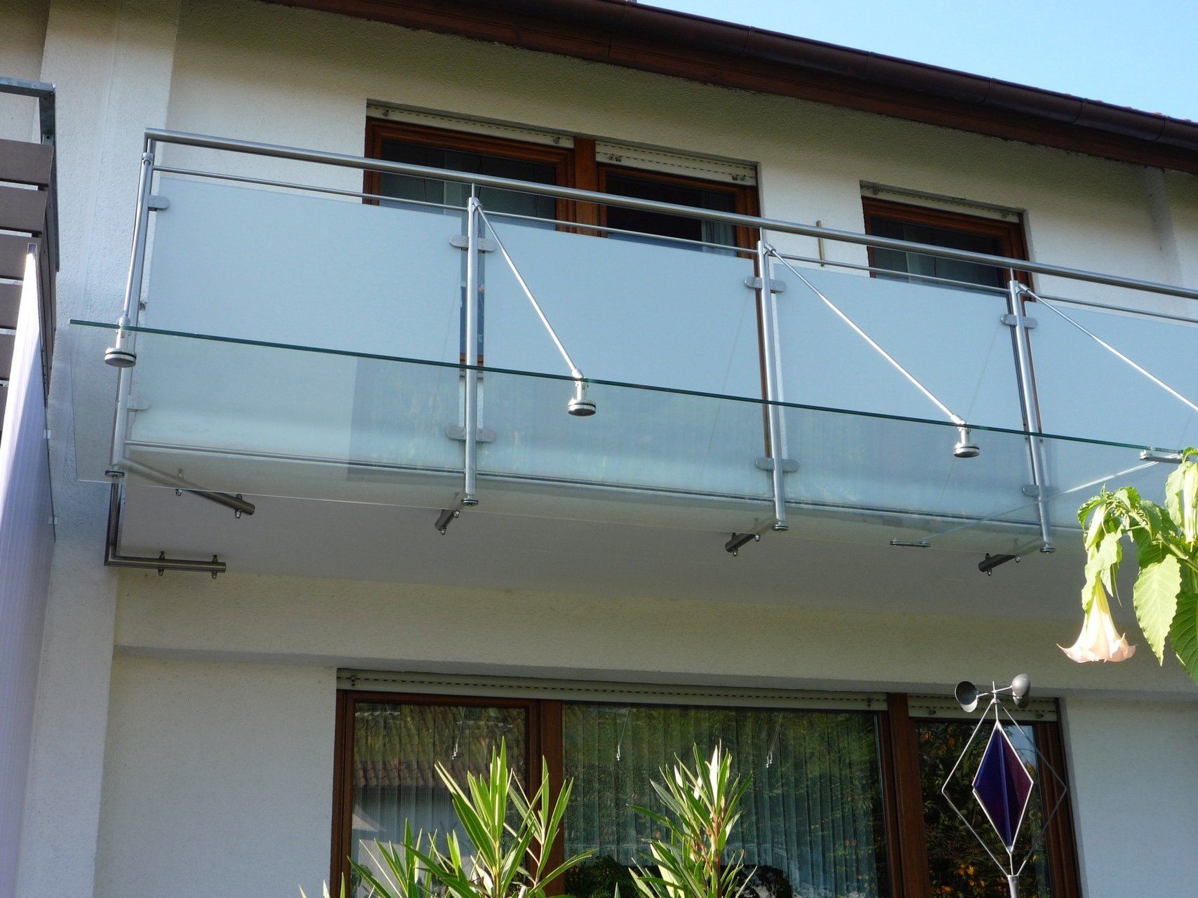 Ein Balkon mit Edelstahlgeländer und Milchglas