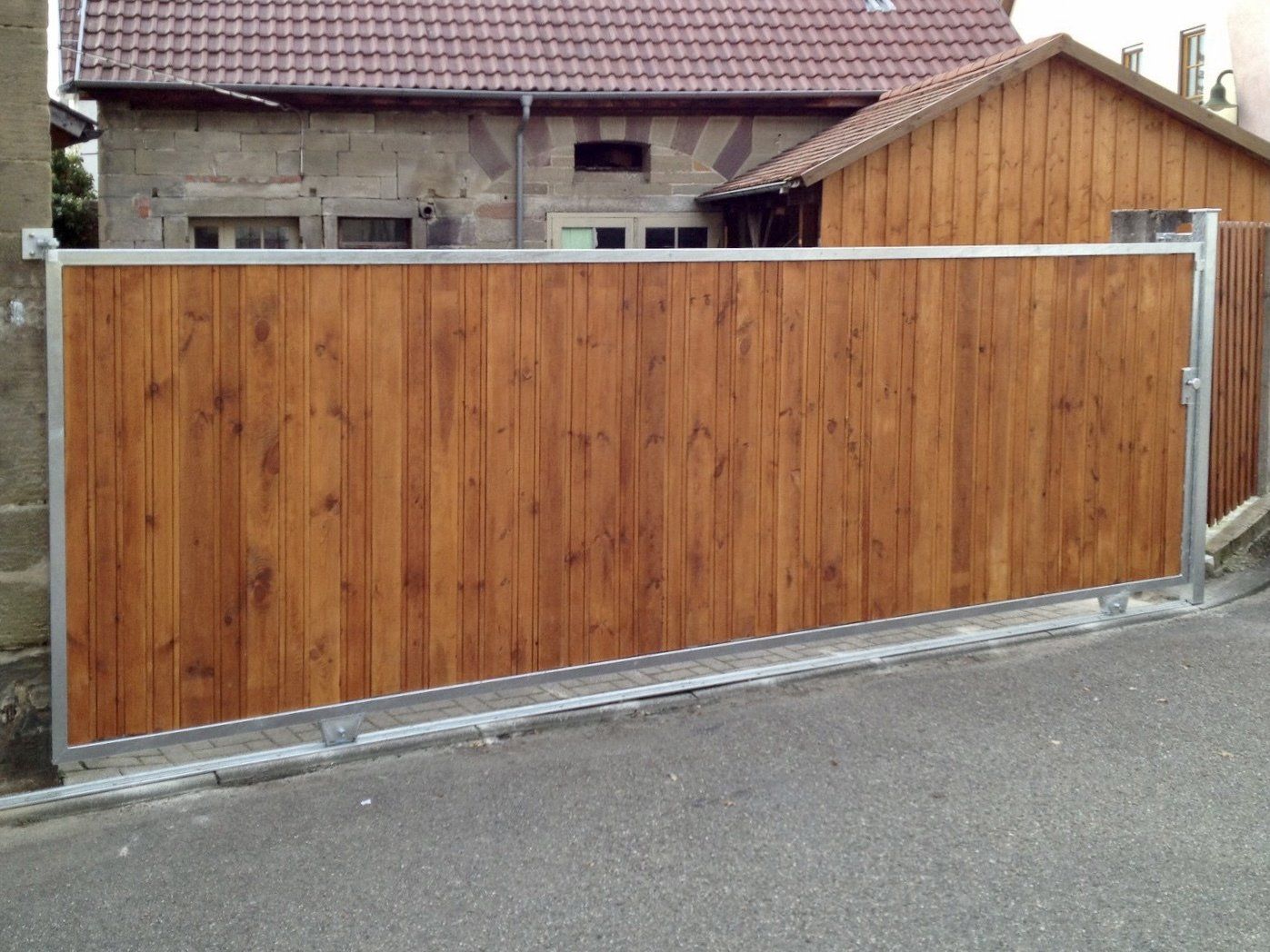 Ein Holzzaun ist vor einem Haus