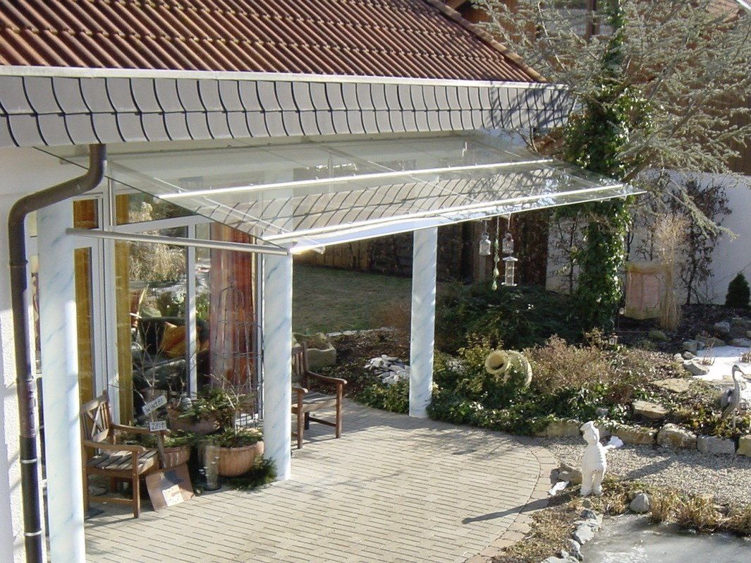 Ein Haus mit einer Terrasse und einem Vordach darüber