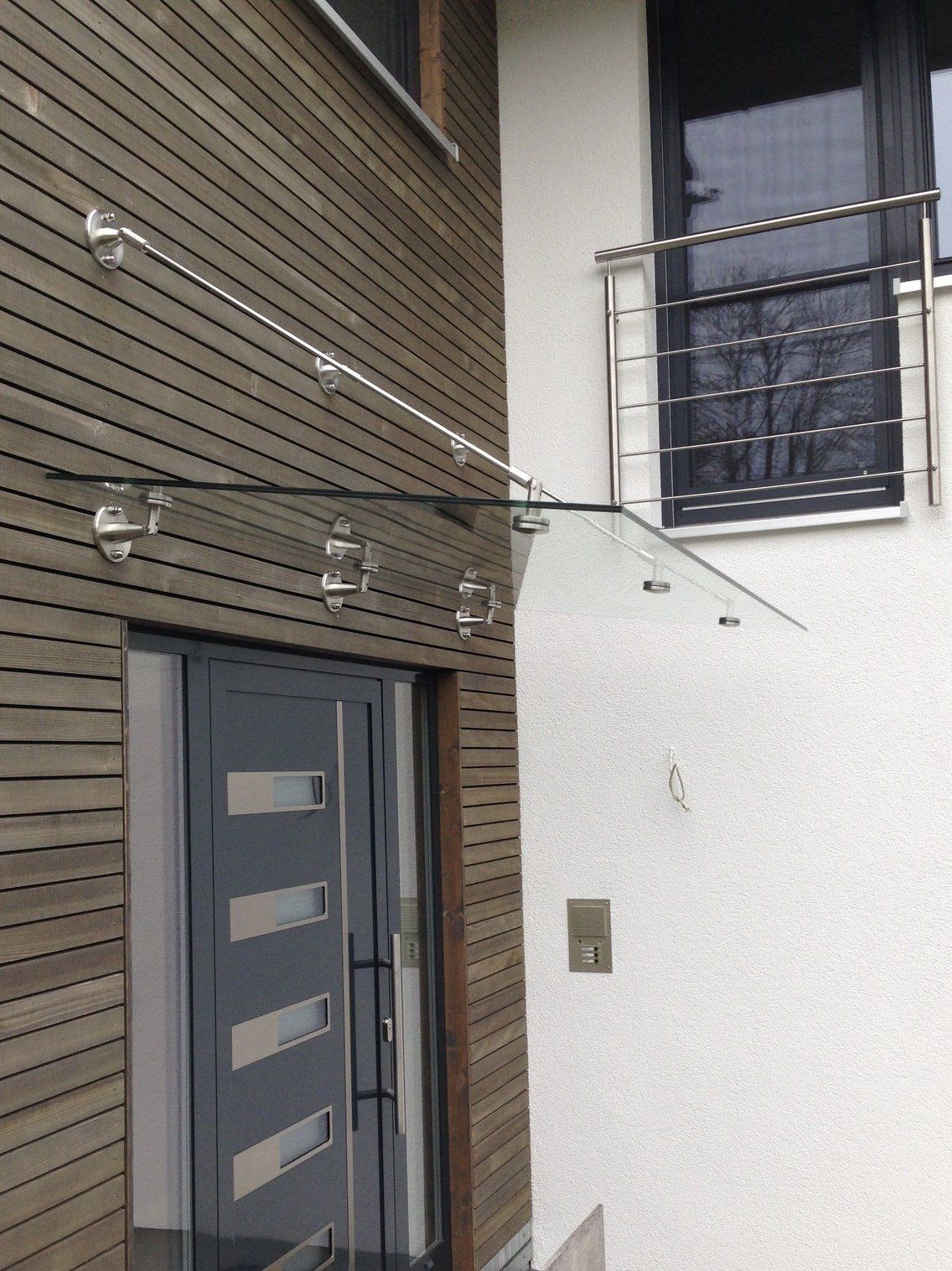 Die Eingangstür eines Hauses ist mit einem Glasdach versehen