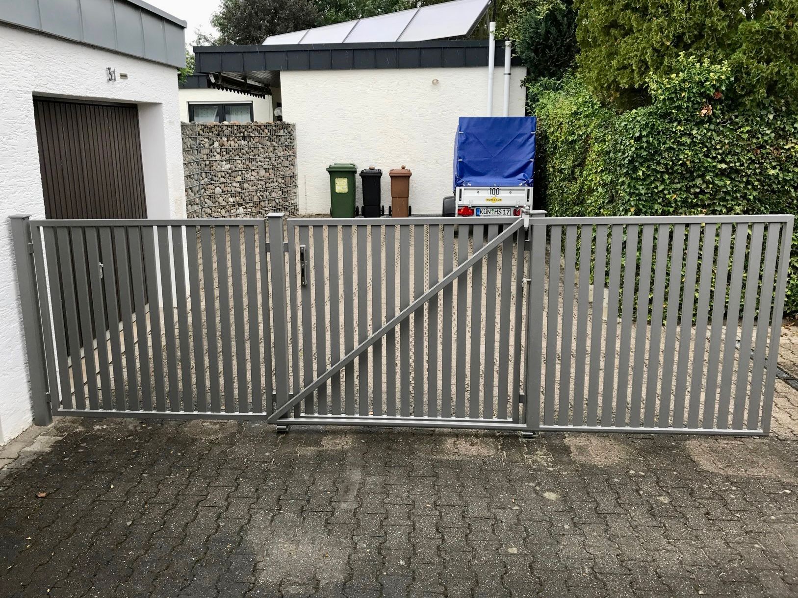 Vor einer Garage ist ein Schiebetor geöffnet
