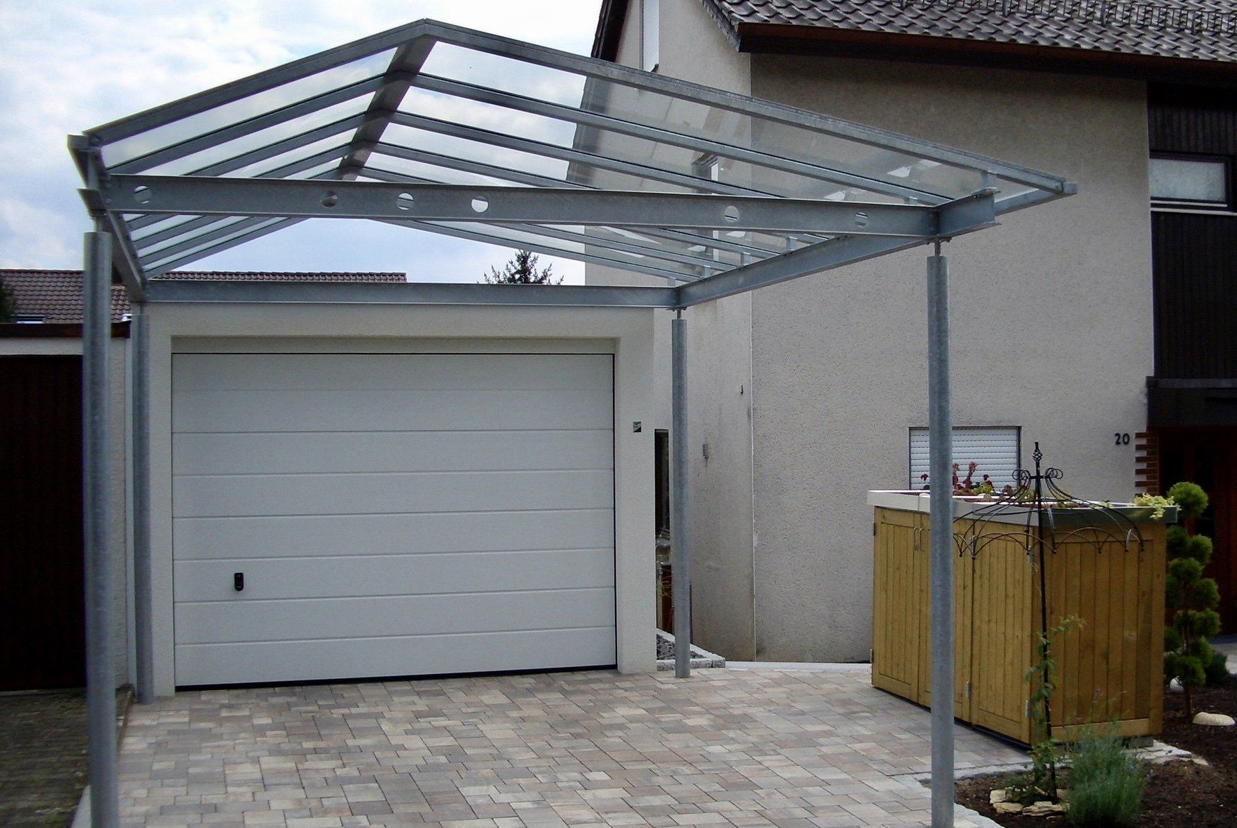 Ein weißes Garagentor mit einem Vordach darüber