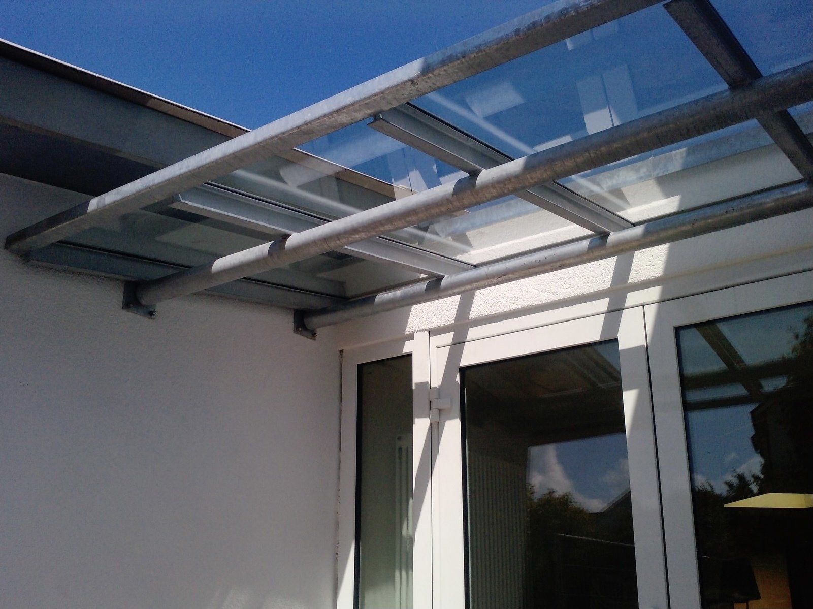 Ein weißes Gebäude mit einem Glasdach über einer Tür