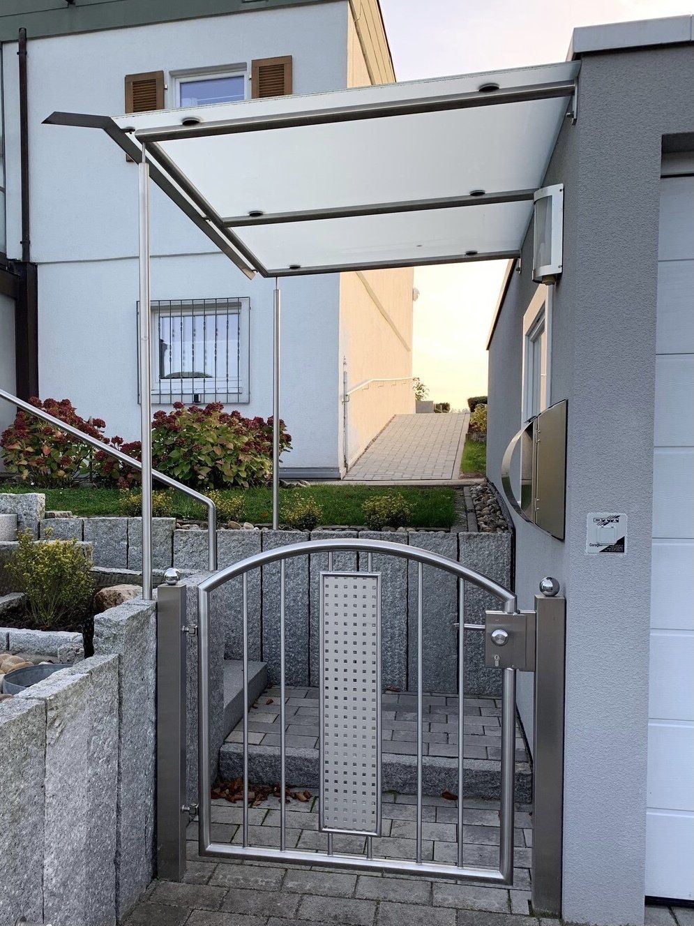 Ein Edelstahltor mit einem Vordach darüber