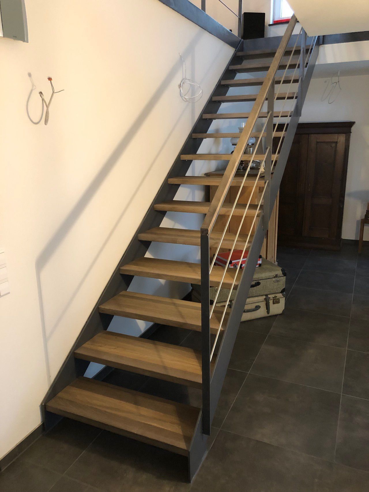 Eine Holztreppe mit einem Metallgeländer in einem Raum.