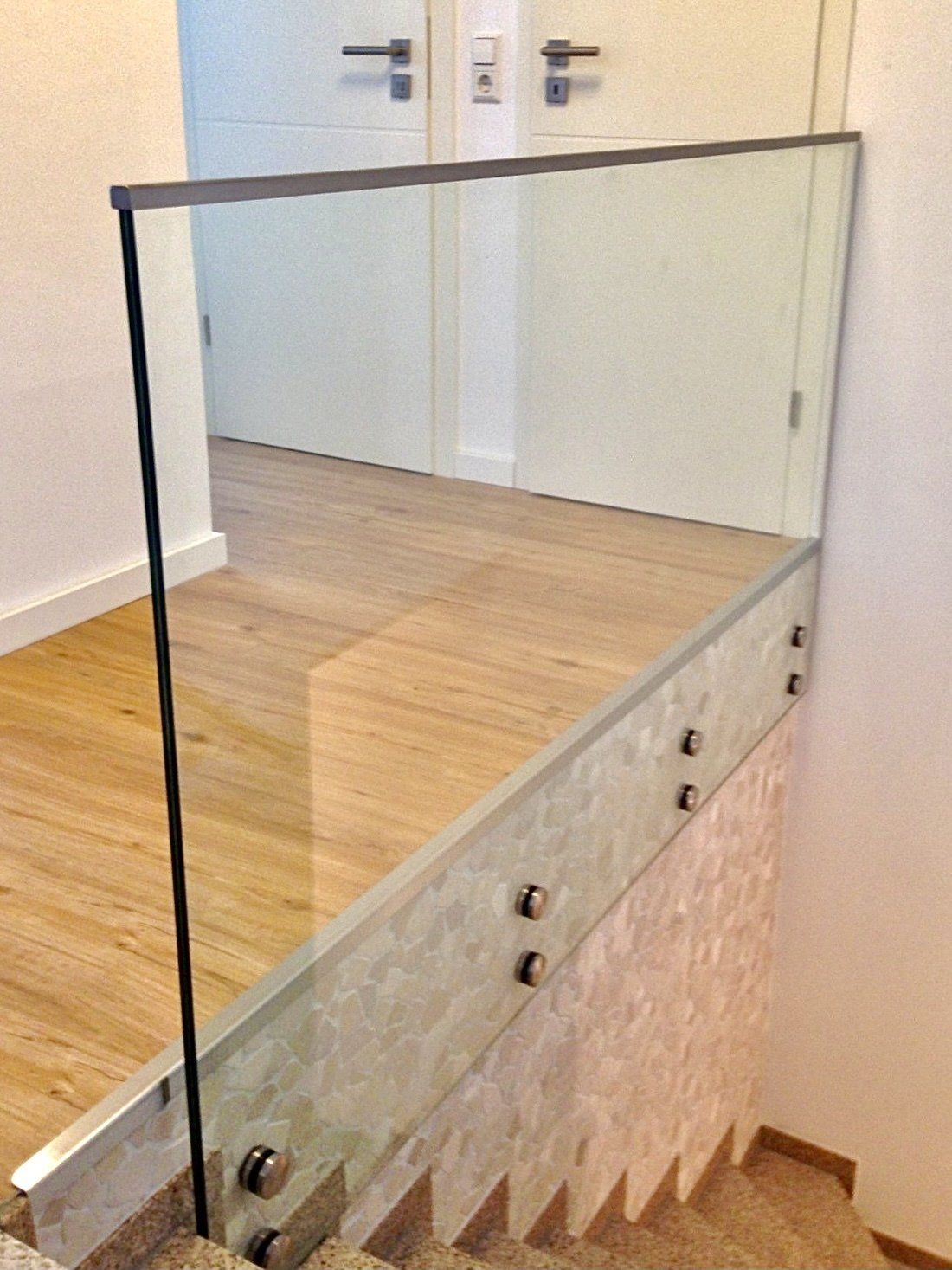 Eine Treppe mit Glasgeländer und Holzboden