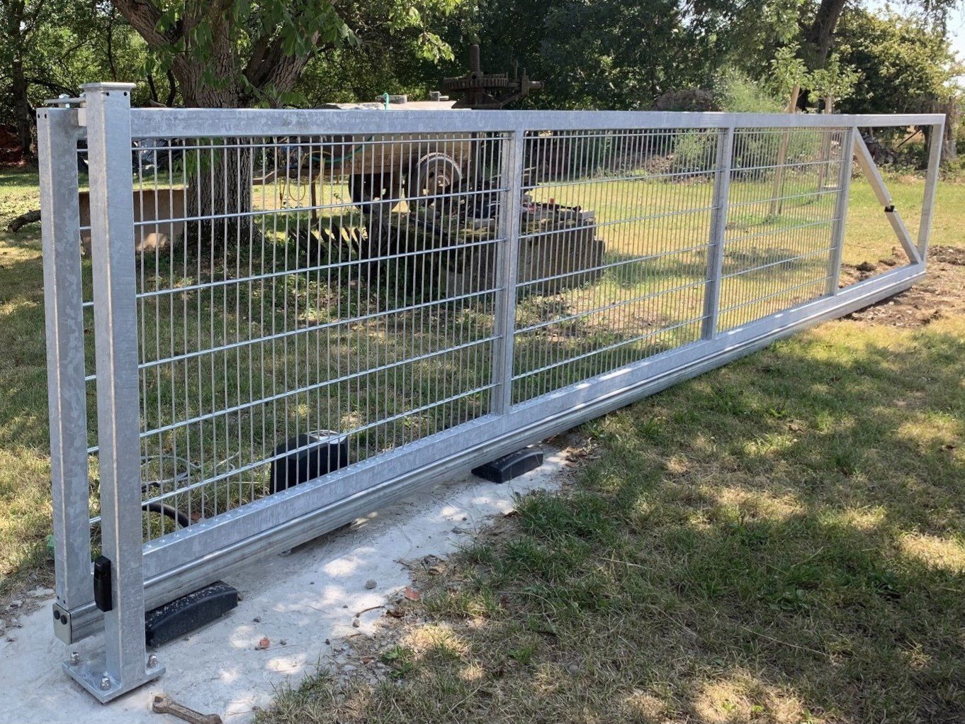 Mitten auf einer Wiese steht ein Schiebetor.