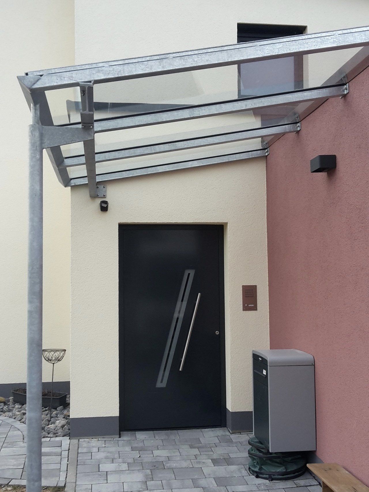 Eine schwarze Tür mit einem Glasdach darüber