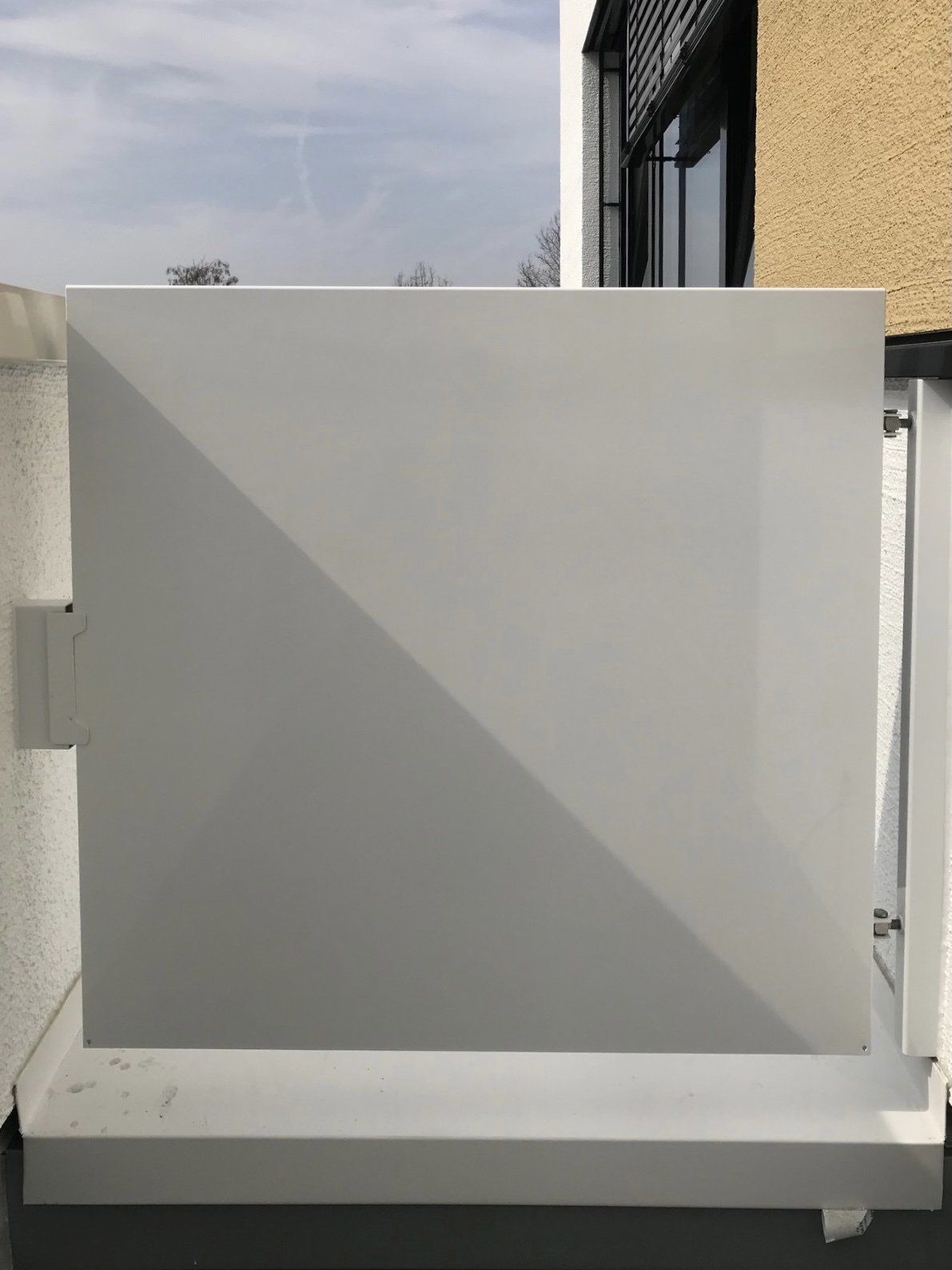 Vor einem Gebäude steht ein weißer Zaun.