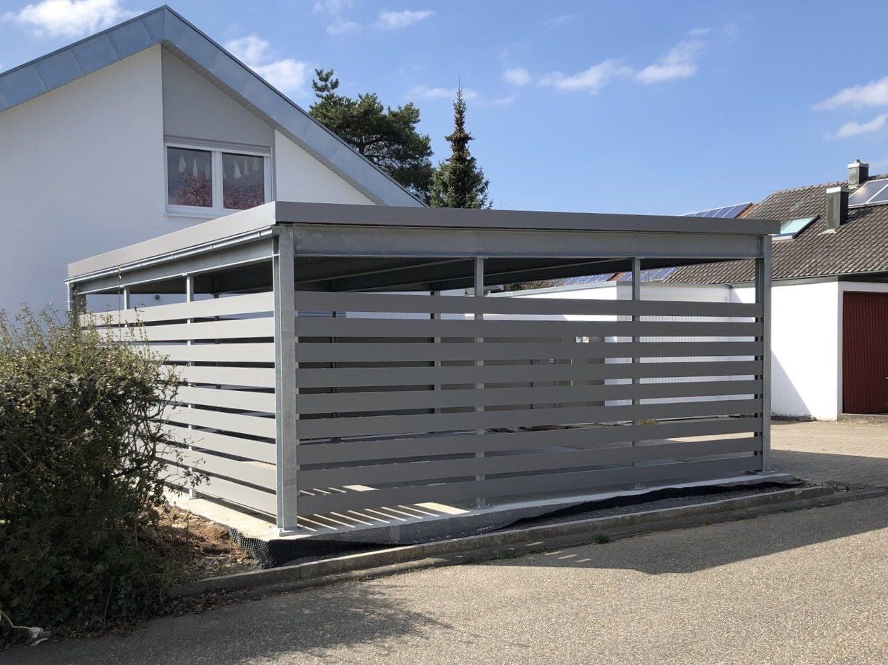 Vor einem Haus steht ein Carport.