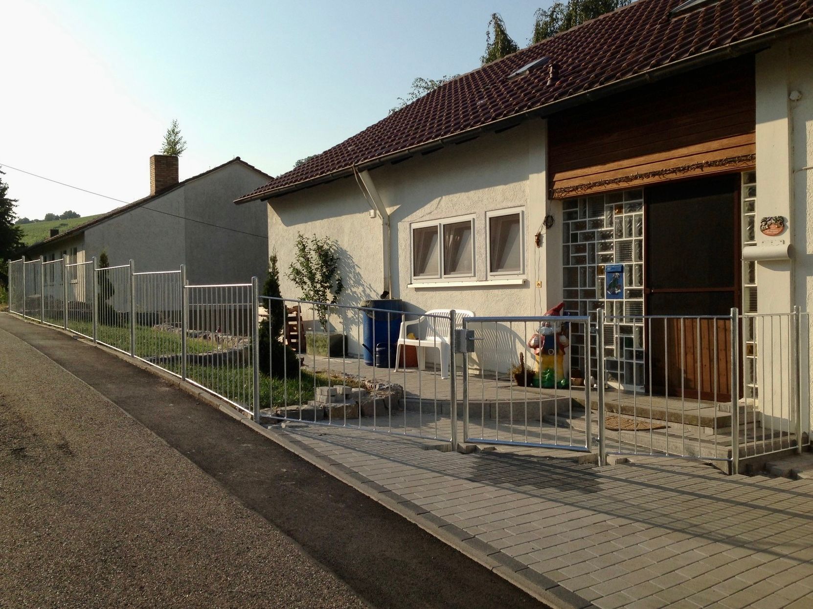 Ein Zaun umgibt ein Haus mit einem Briefkasten an der Seite