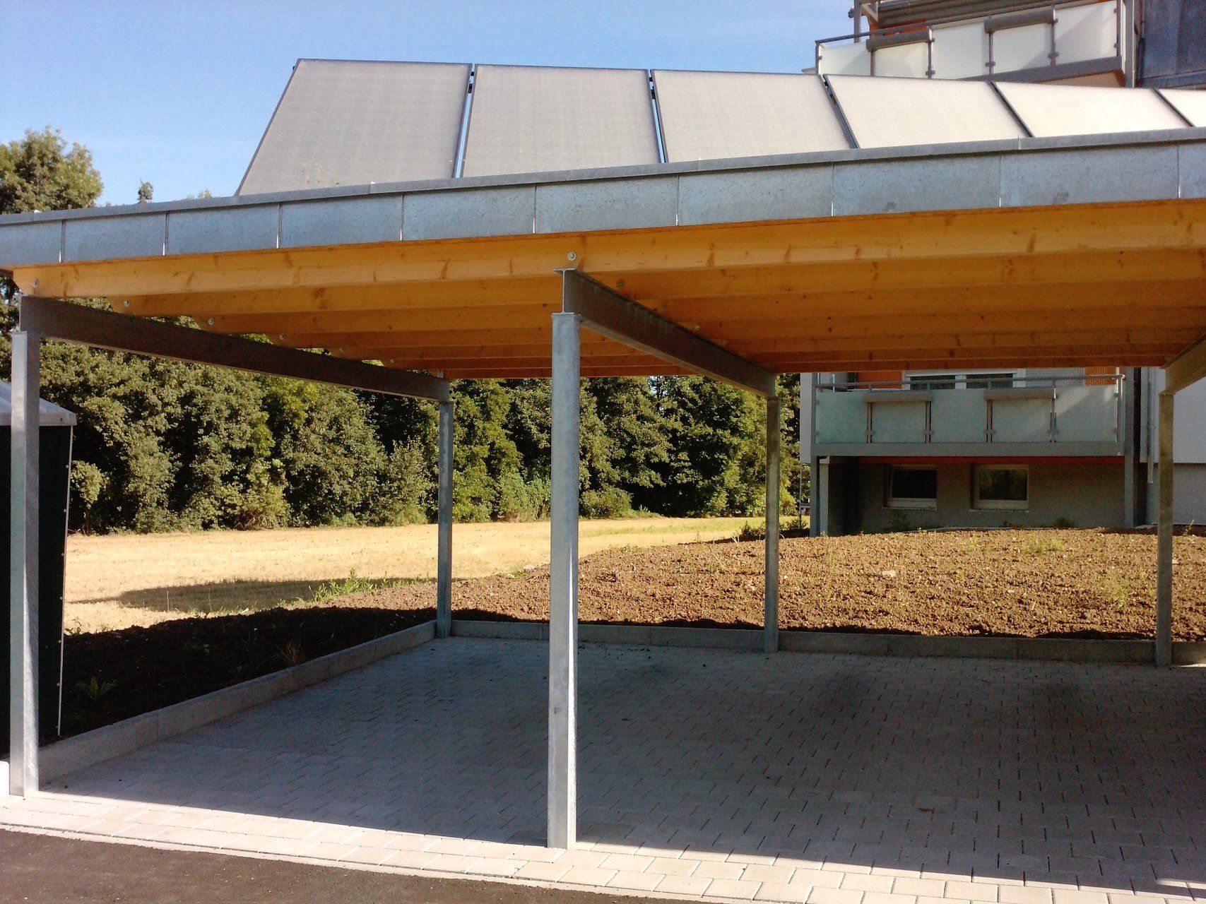 Ein Holzcarport mit Solarmodulen auf dem Dach