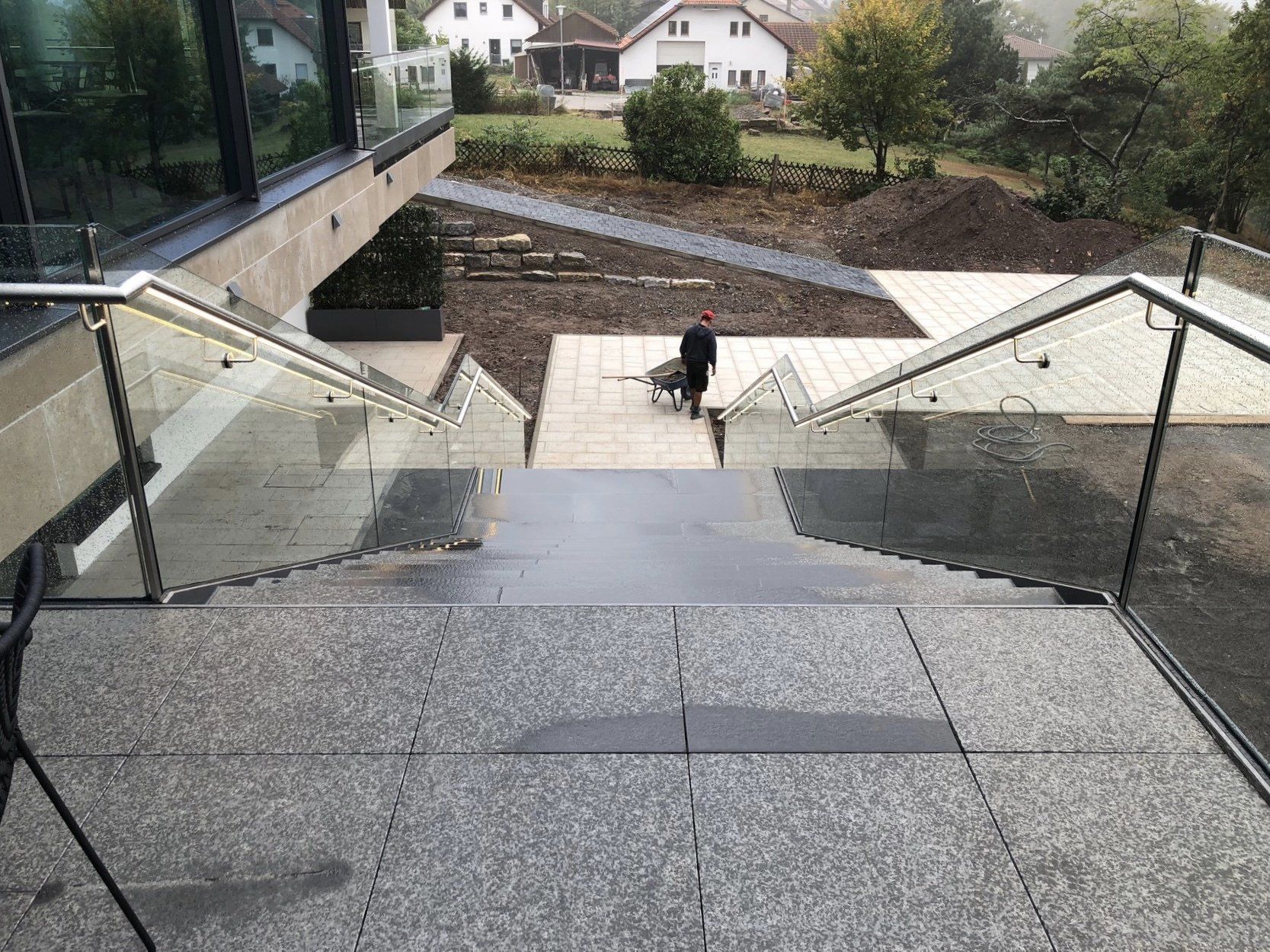 Eine Person geht eine Treppe mit Glasgeländer hinunter.