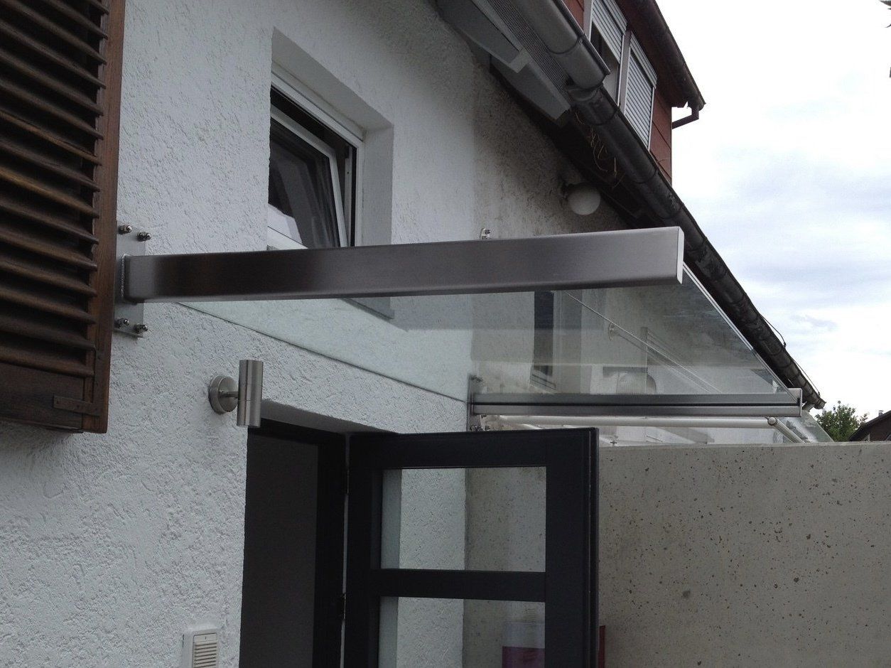 Ein weißes Gebäude mit einem Glasdach über der Tür