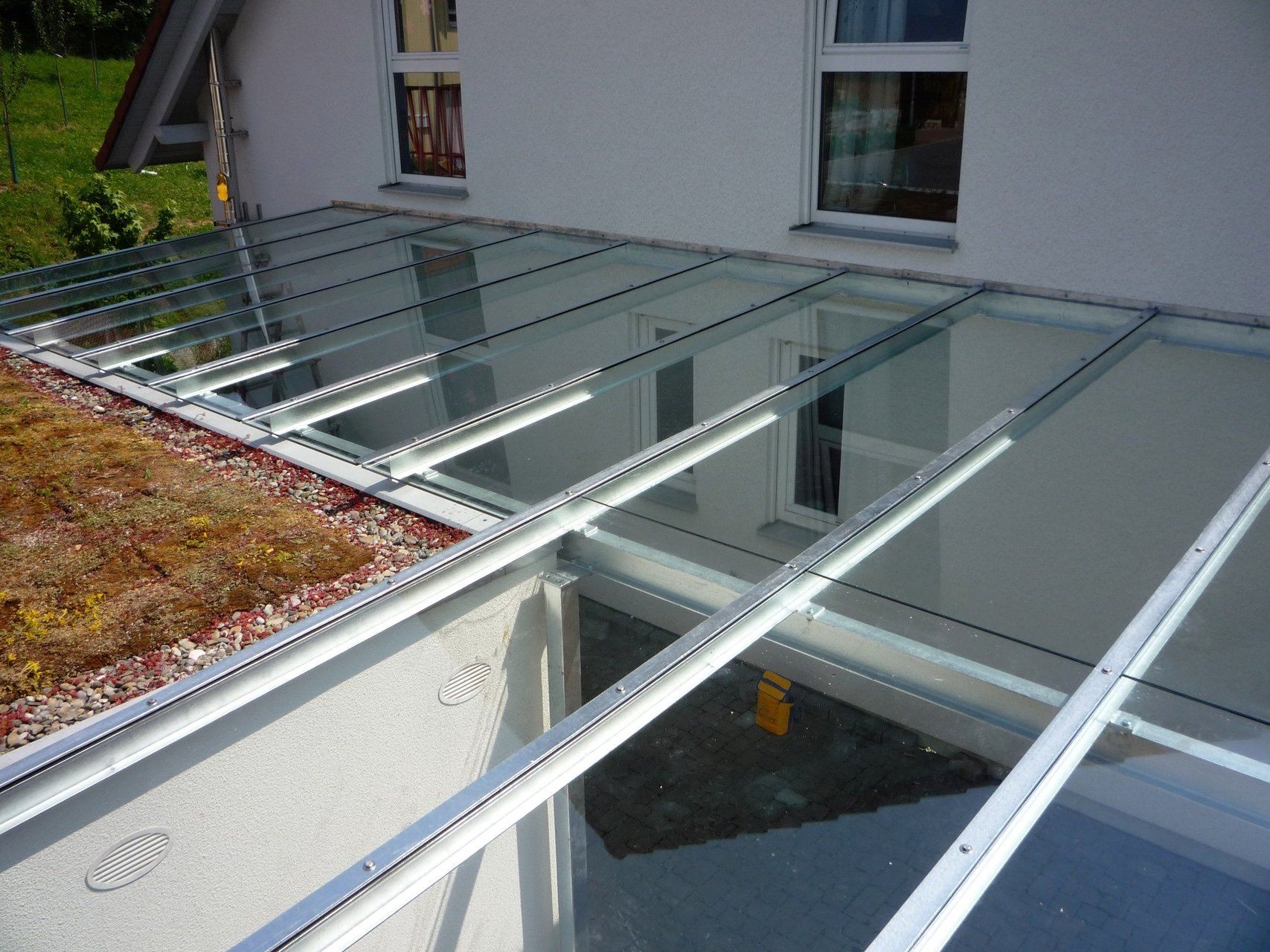 Ein weißes Haus mit einem Glasdach und einem Gründach