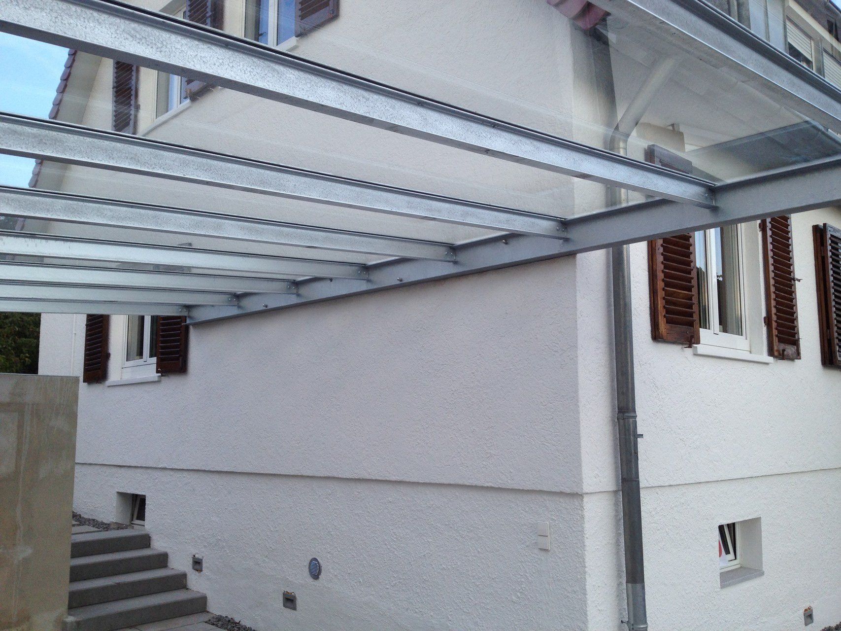 Ein weißes Haus mit Glasdach und Treppe