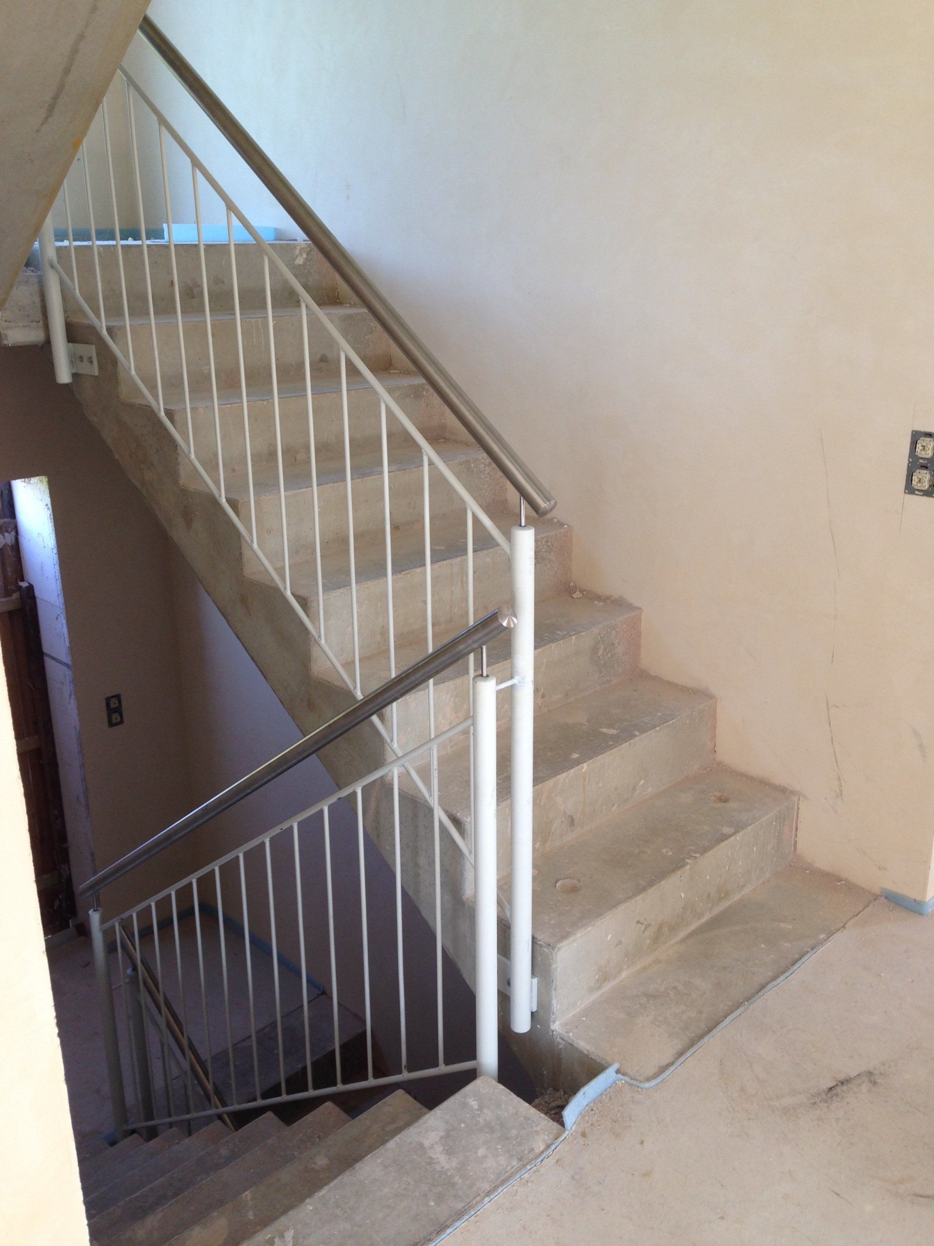 Eine Treppe mit einem weißen Geländer und ein paar Stufen