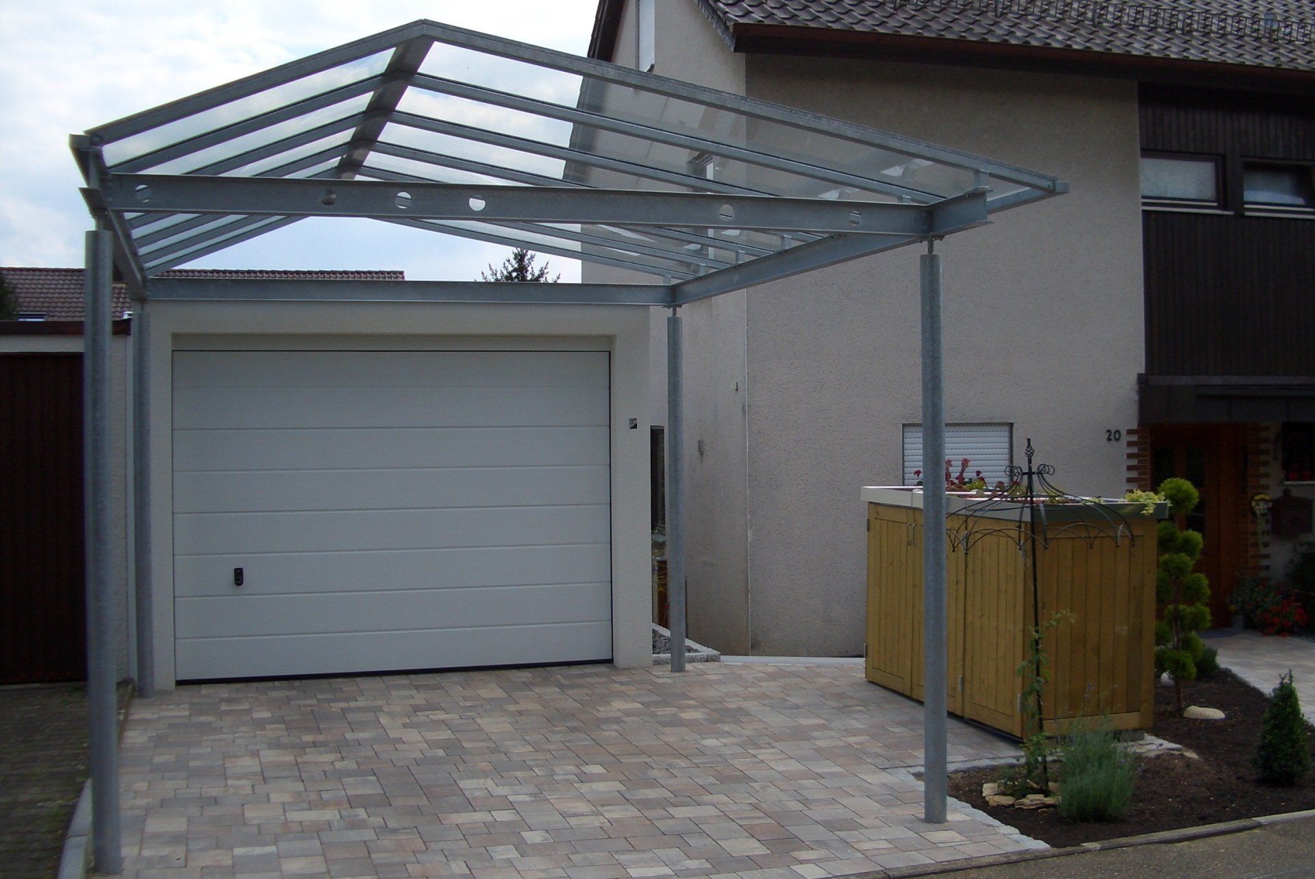 Ein weißes Garagentor mit einem Vordach darüber