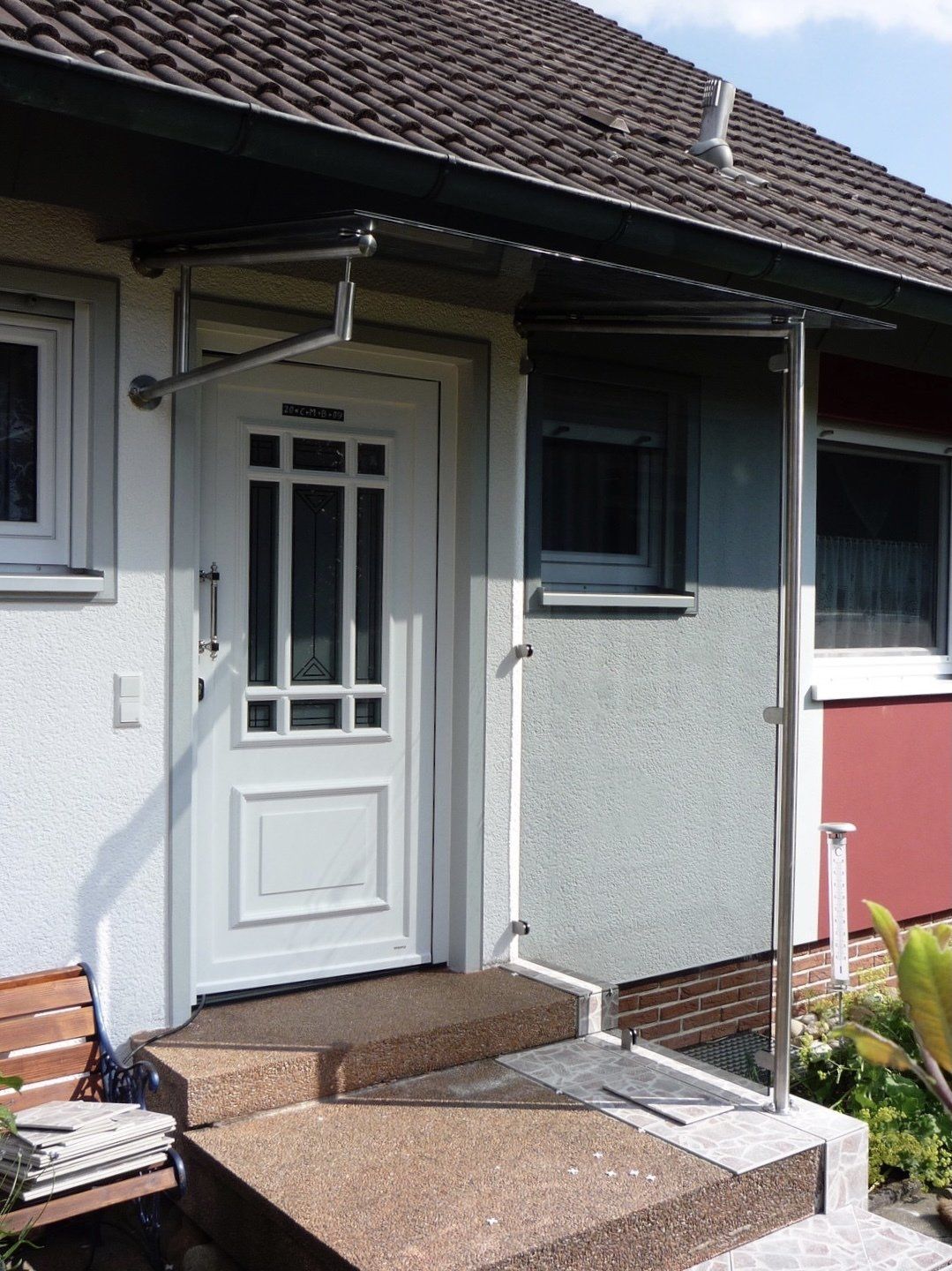 Die Haustür eines Hauses ist mit einem Vordach versehen