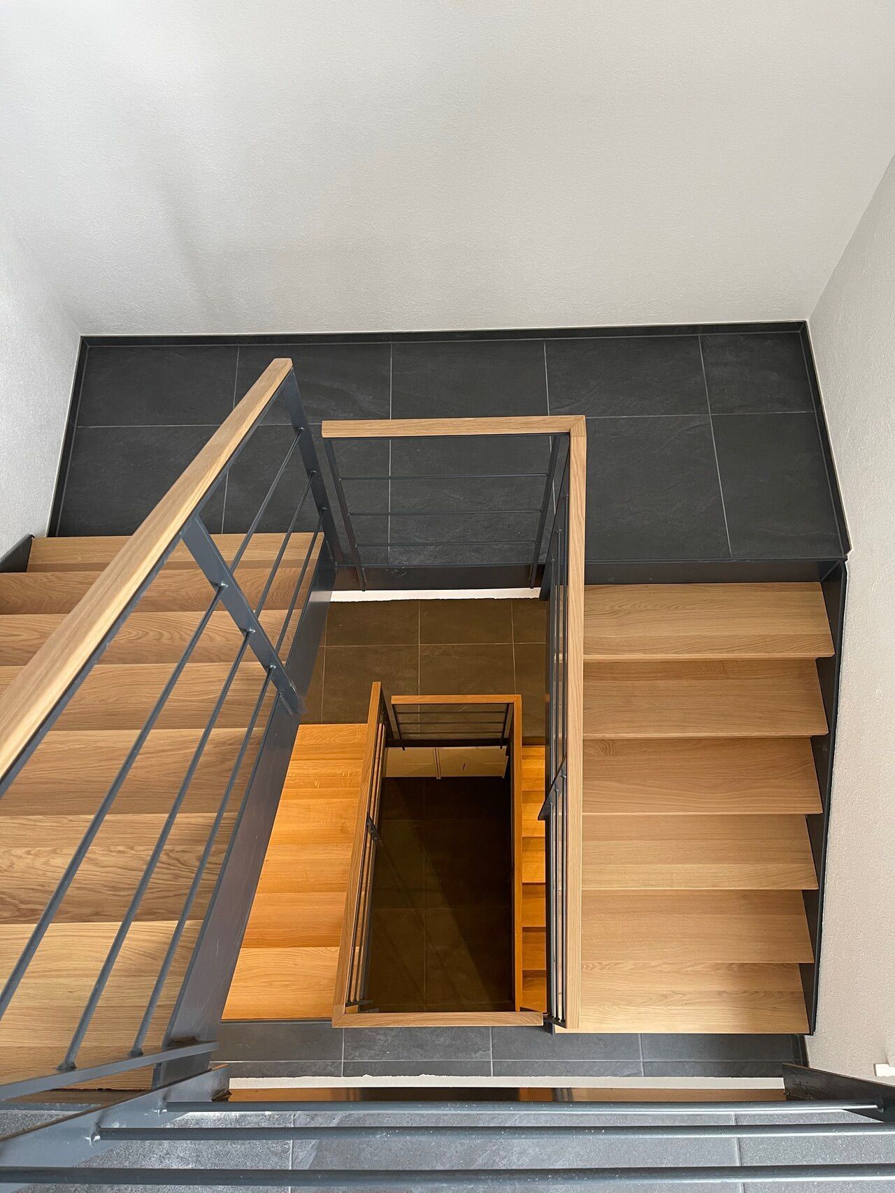 Eine Luftaufnahme einer Holztreppe mit einem Metallgeländer.