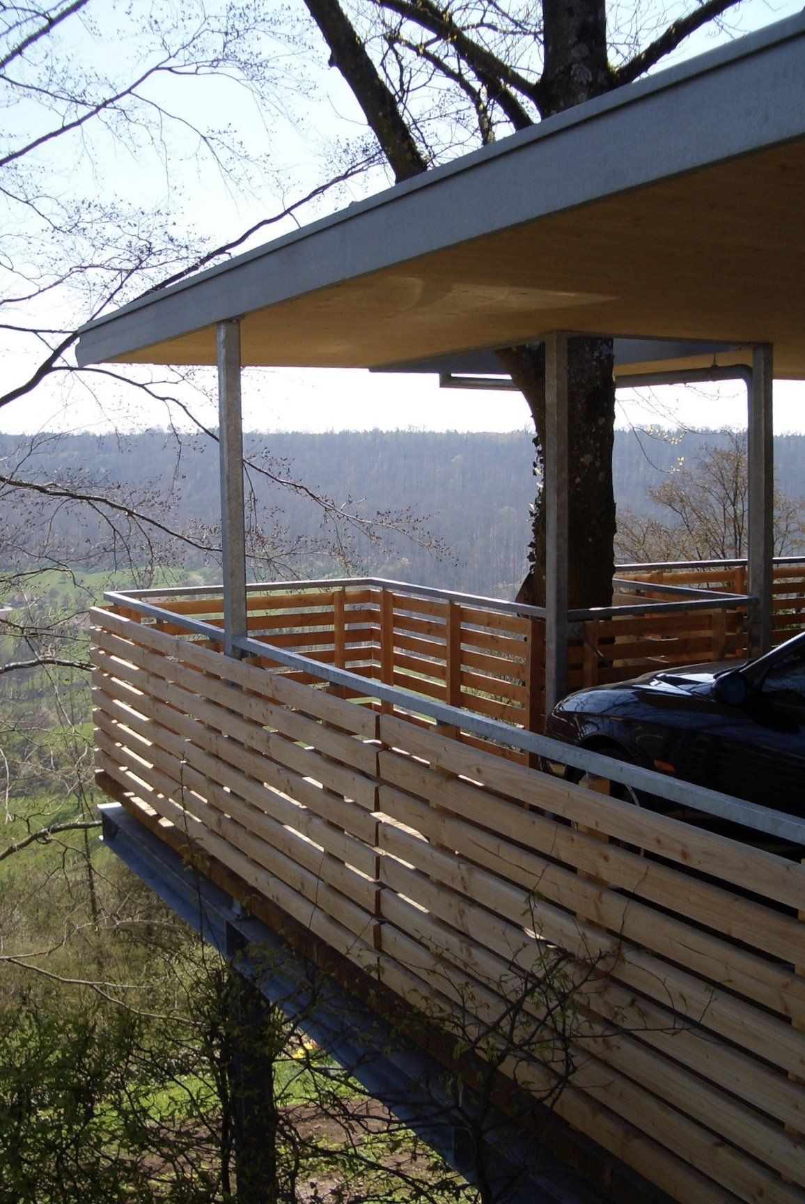 Ein Auto ist auf dem Deck eines Baumhauses geparkt