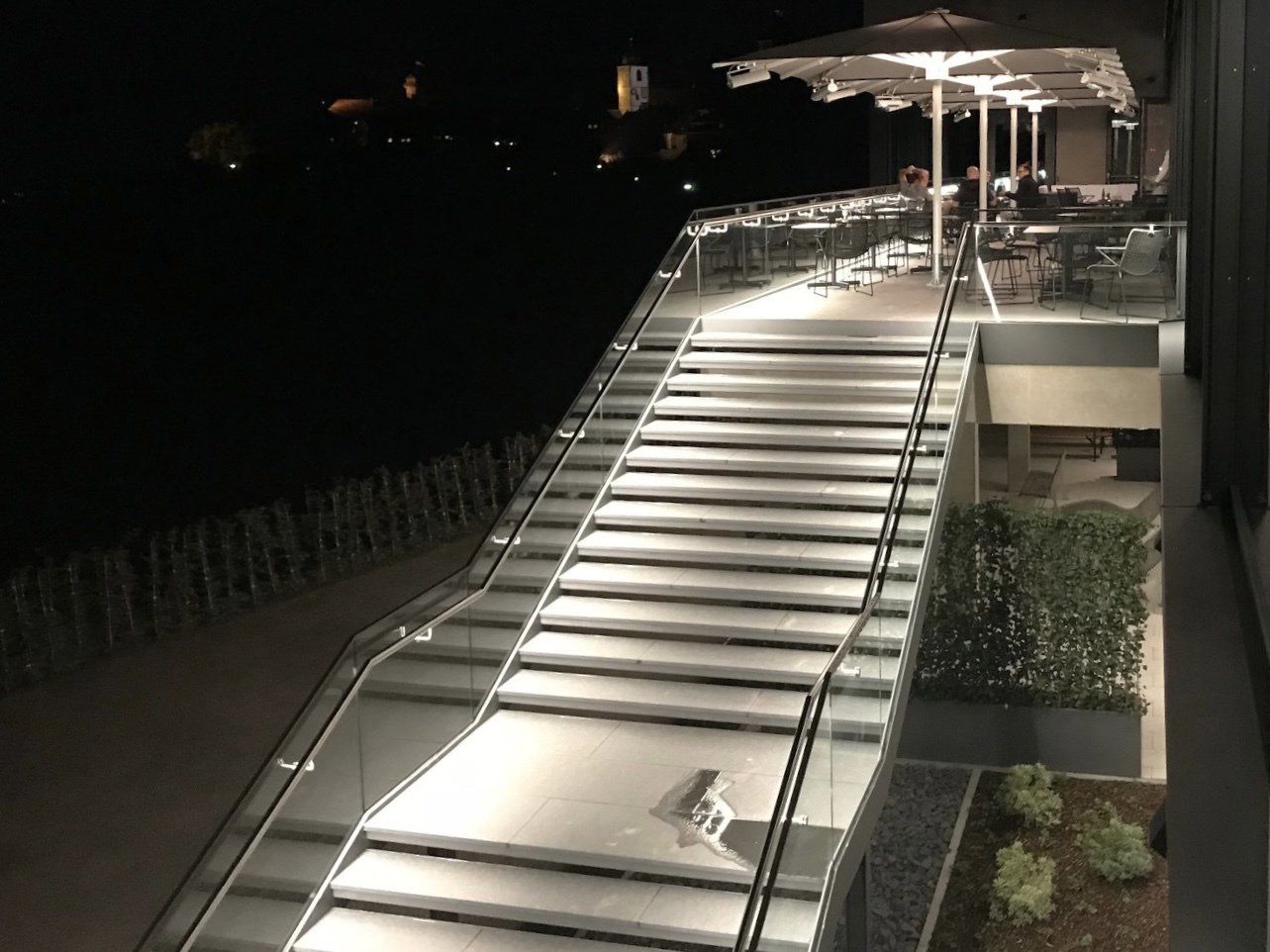 Eine Treppe, die nachts zu einem Balkon hinaufführt.