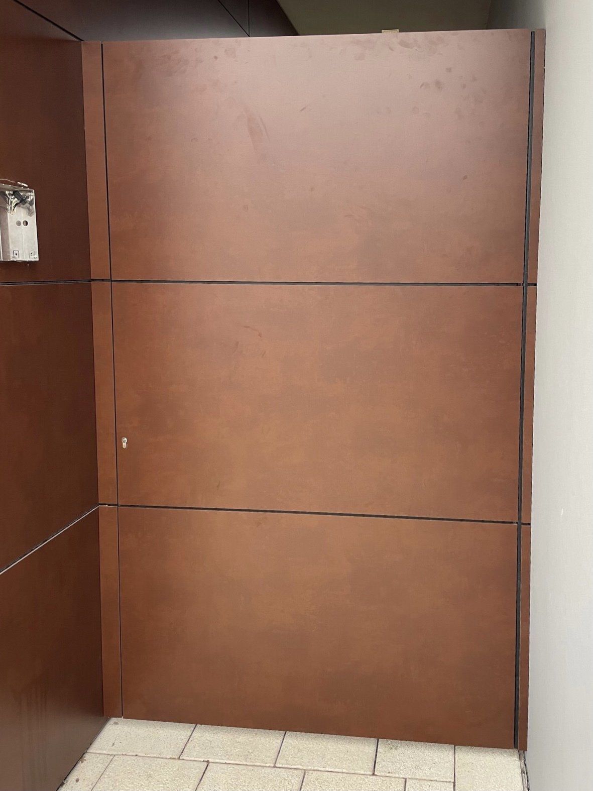 Eine braune Wand mit einem Ziegelboden davor