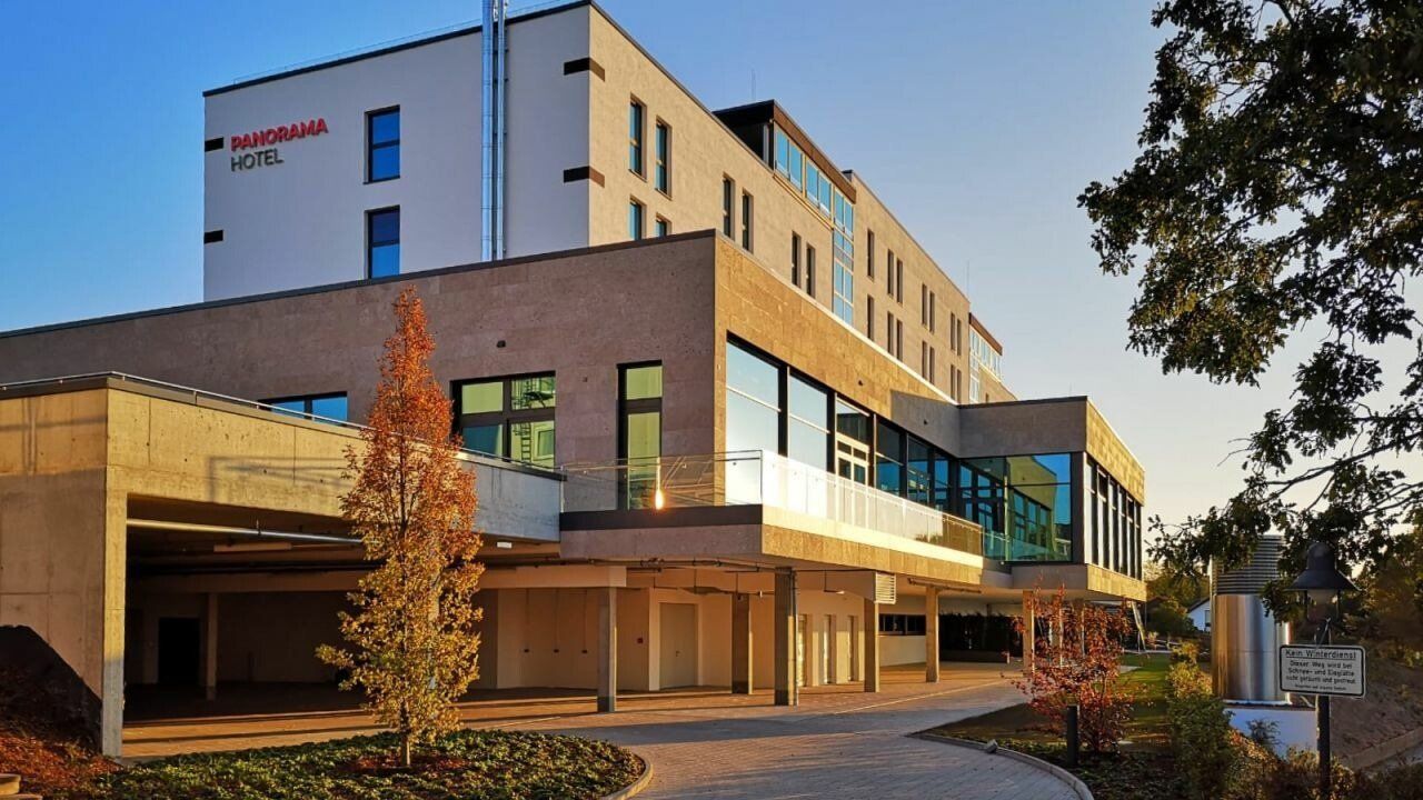 Ein großes Gebäude mit vielen Fenstern und Bäumen davor