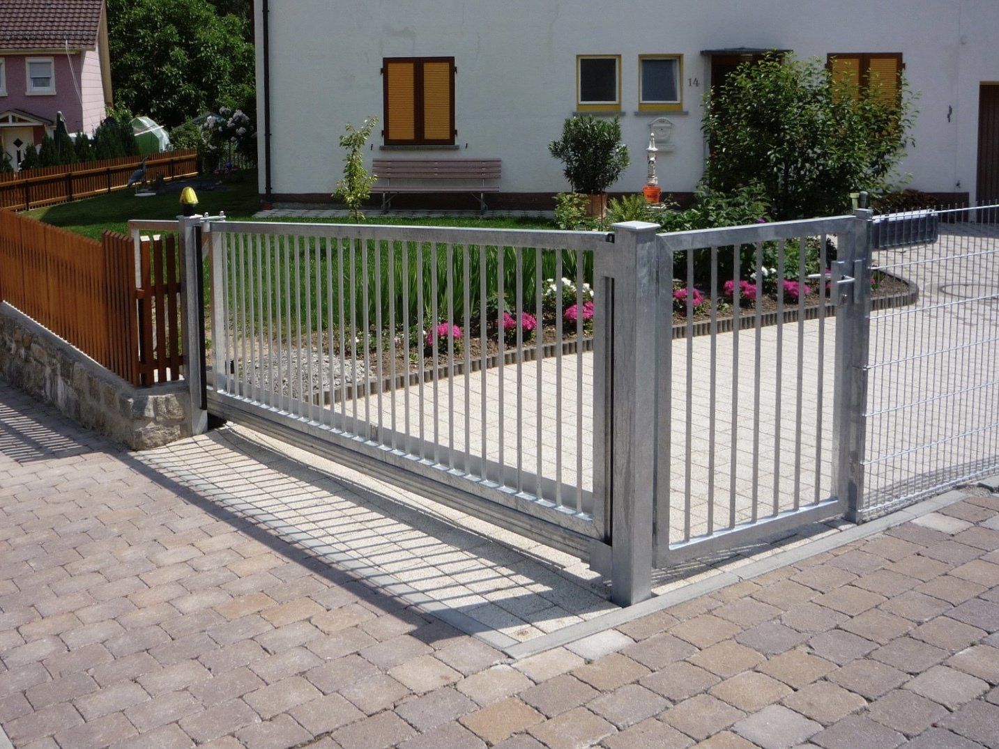 Vor einem Haus ist ein Schiebetor geöffnet