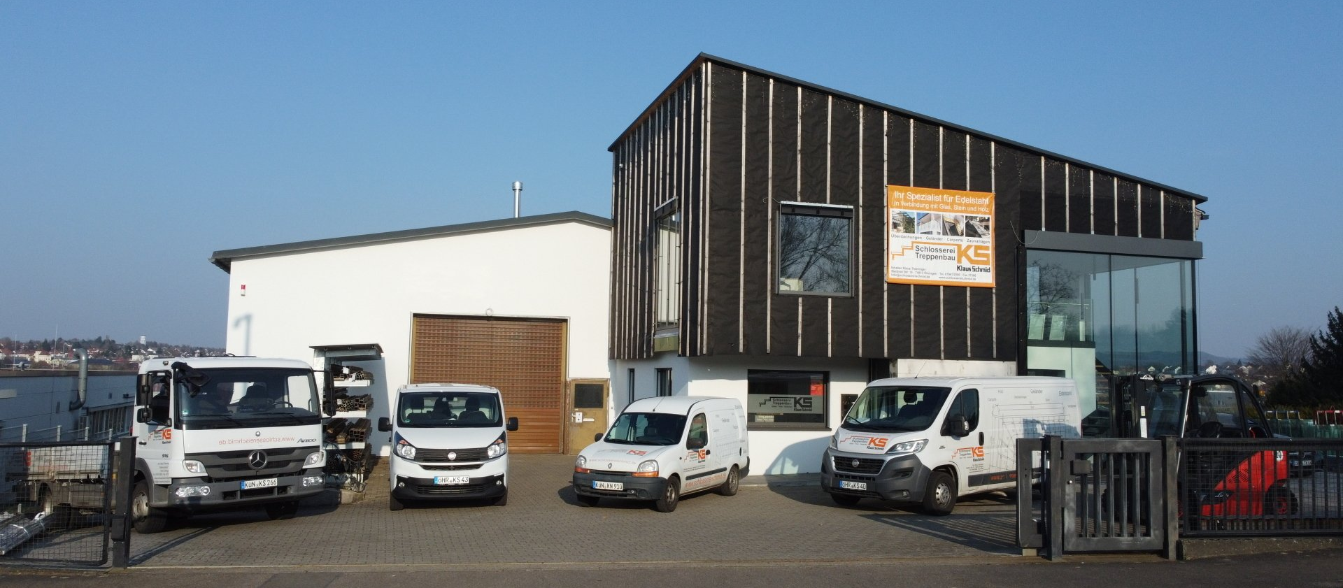 Eine Reihe weißer Lieferwagen, die vor einem Gebäude geparkt sind