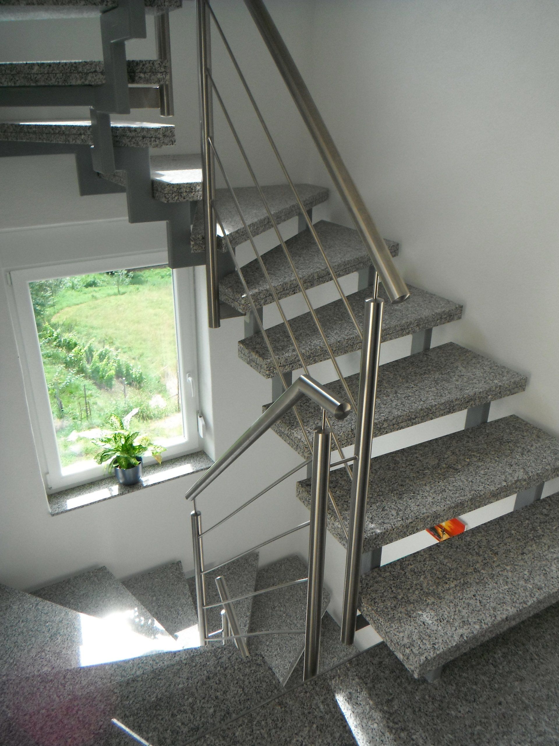 Eine Treppe mit Edelstahlgeländer und Fenster