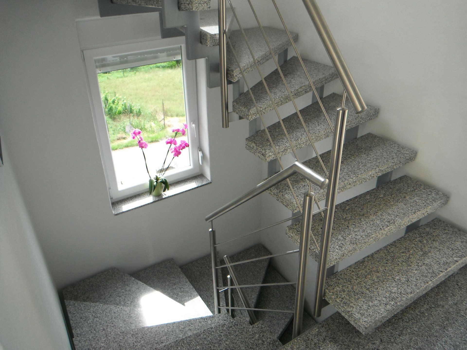 Eine Treppe mit Edelstahlgeländer und Fenster