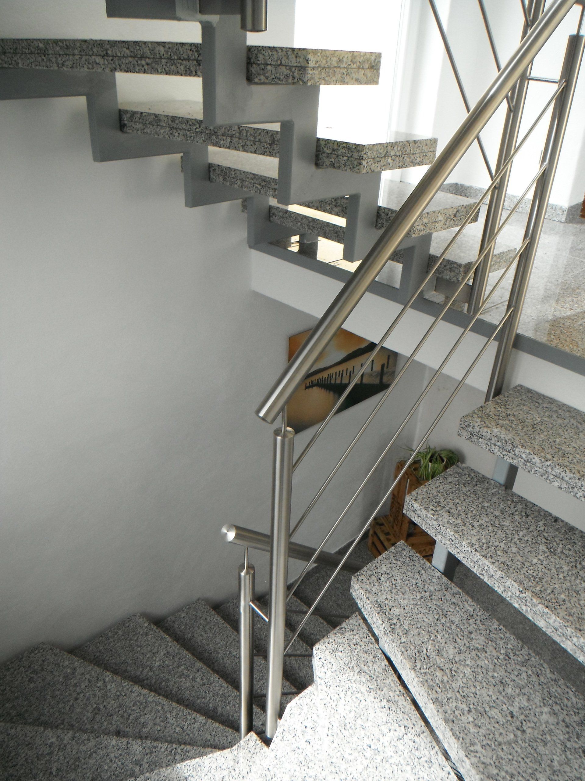 Eine Treppe mit Granitstufen und einem Edelstahlgeländer