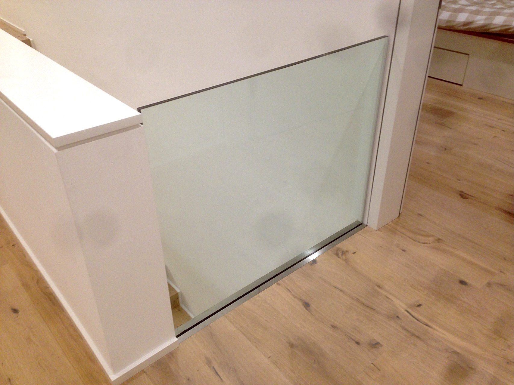 Eine Treppe mit Glasgeländer und Holzboden