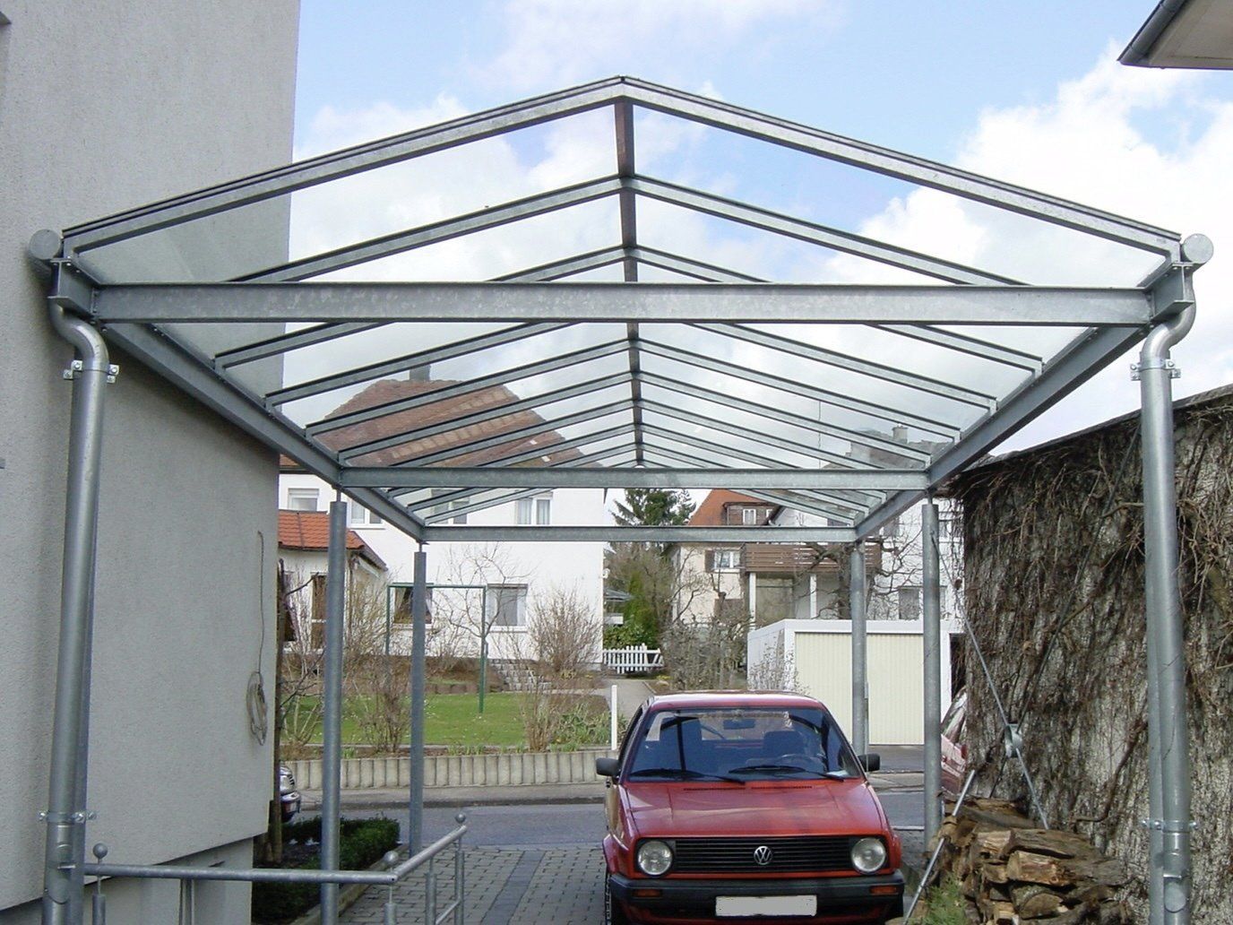 Ein rotes Auto ist unter einem Glasdach geparkt