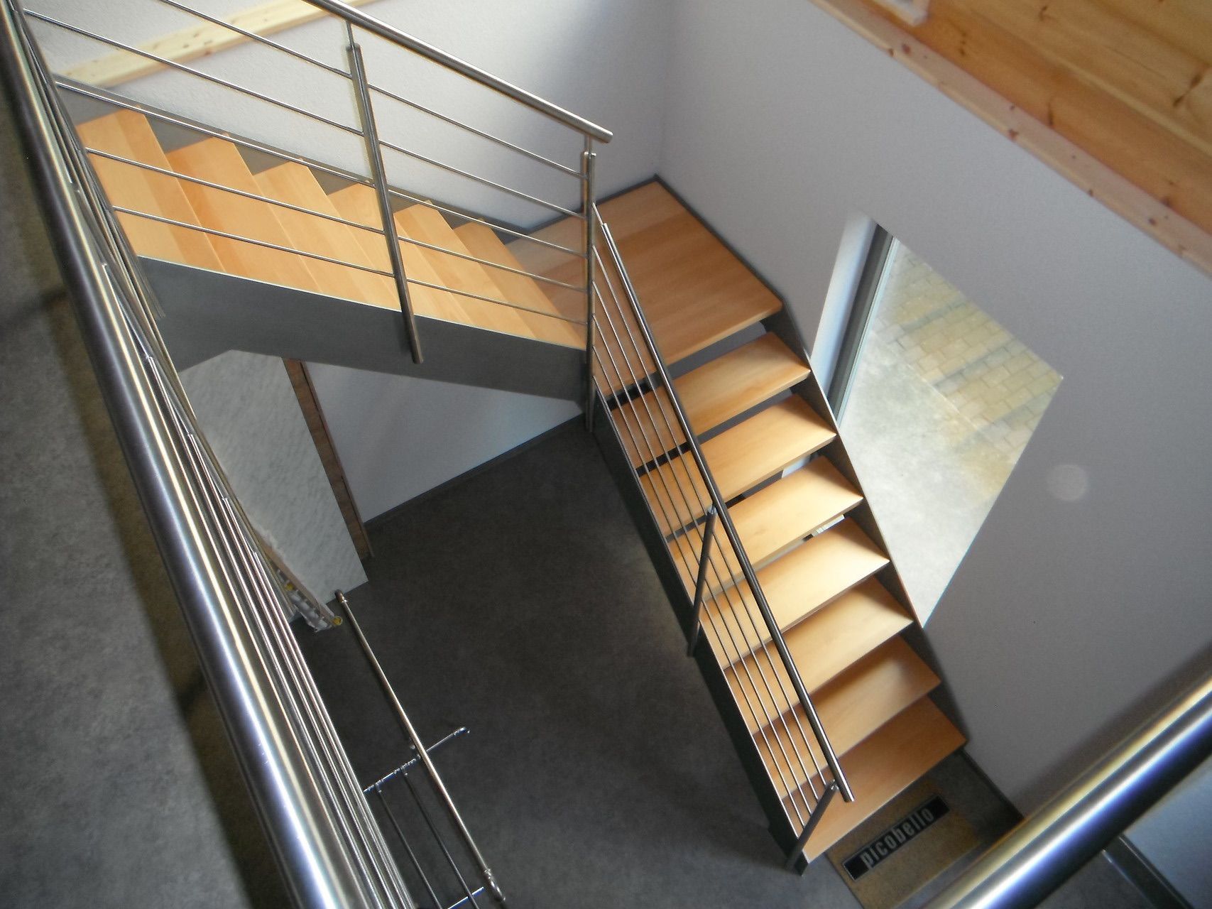 Eine Treppe mit Edelstahlgeländer und Holzstufen