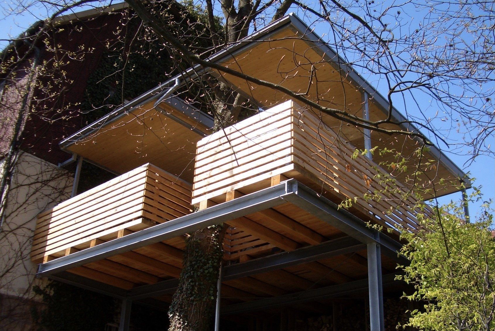 Ein Haus mit Balkon und einem Baum im Hintergrund