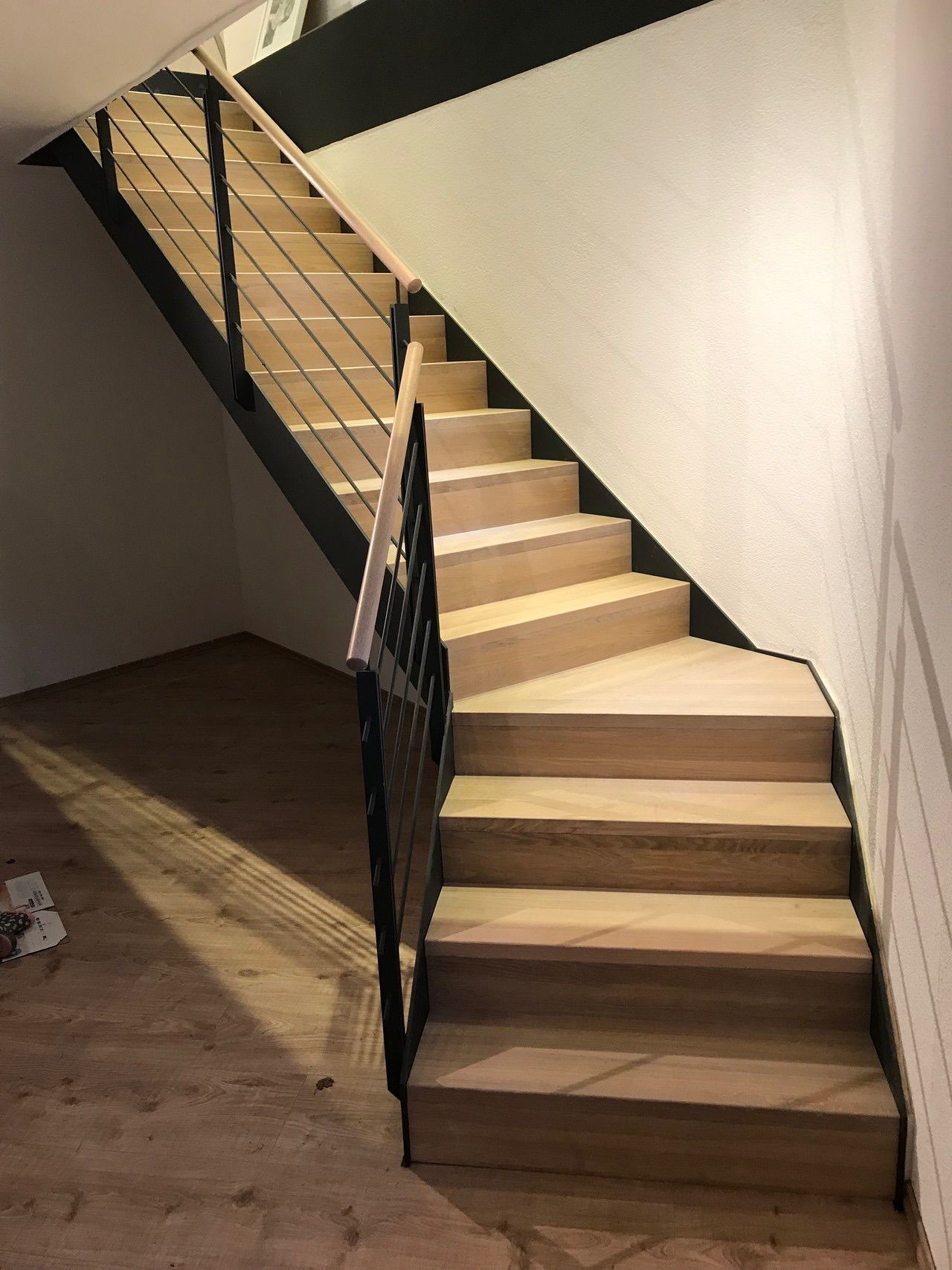 Eine Holztreppe mit einem Metallgeländer in einem Raum.