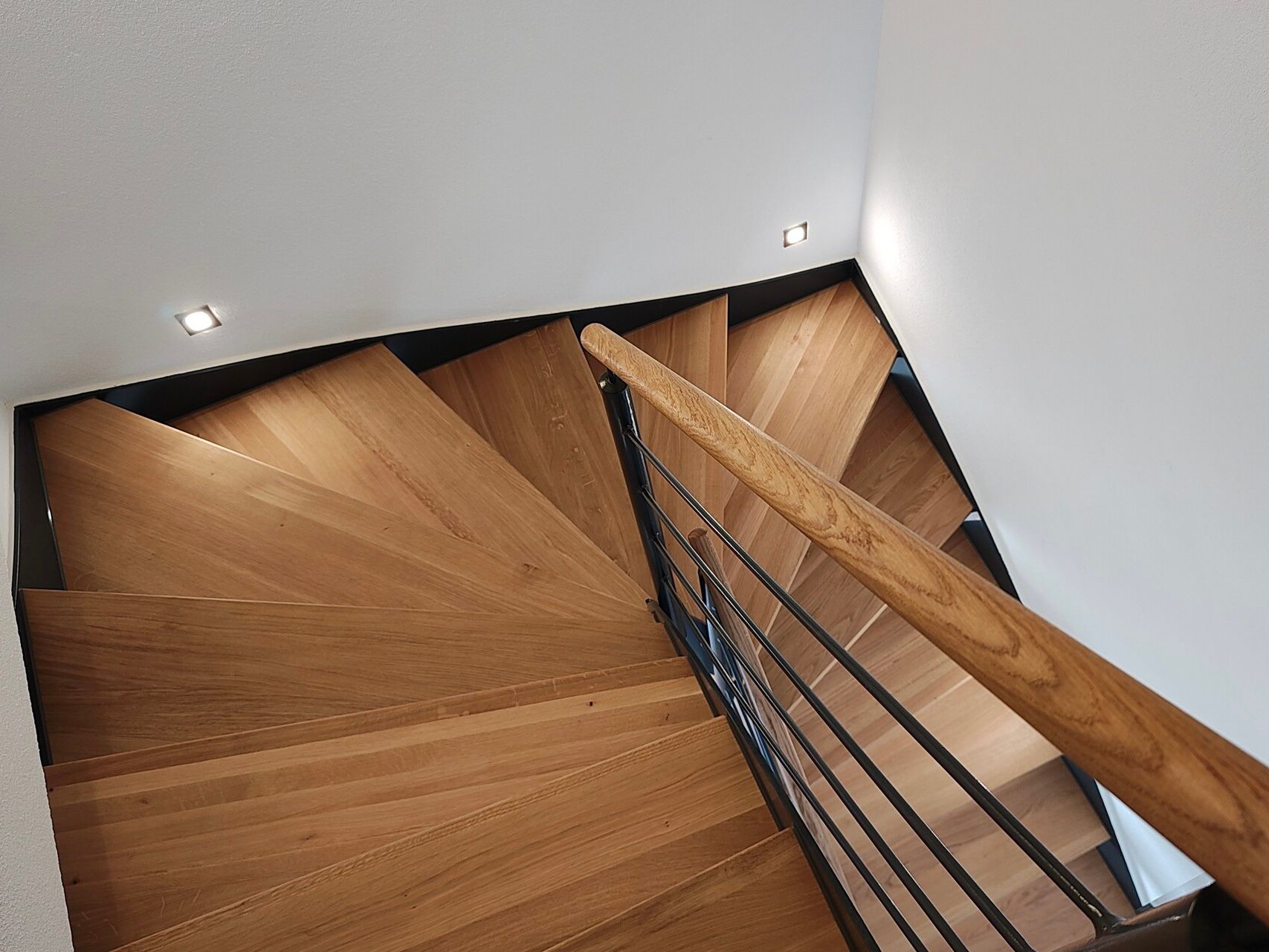 Eine hölzerne Wendeltreppe mit einem Metallgeländer