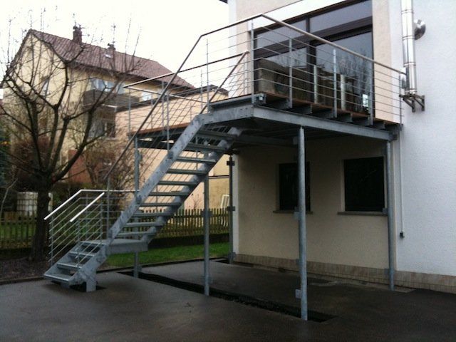 Eine Metalltreppe, die zu einem Balkon an der Seite eines Gebäudes führt
